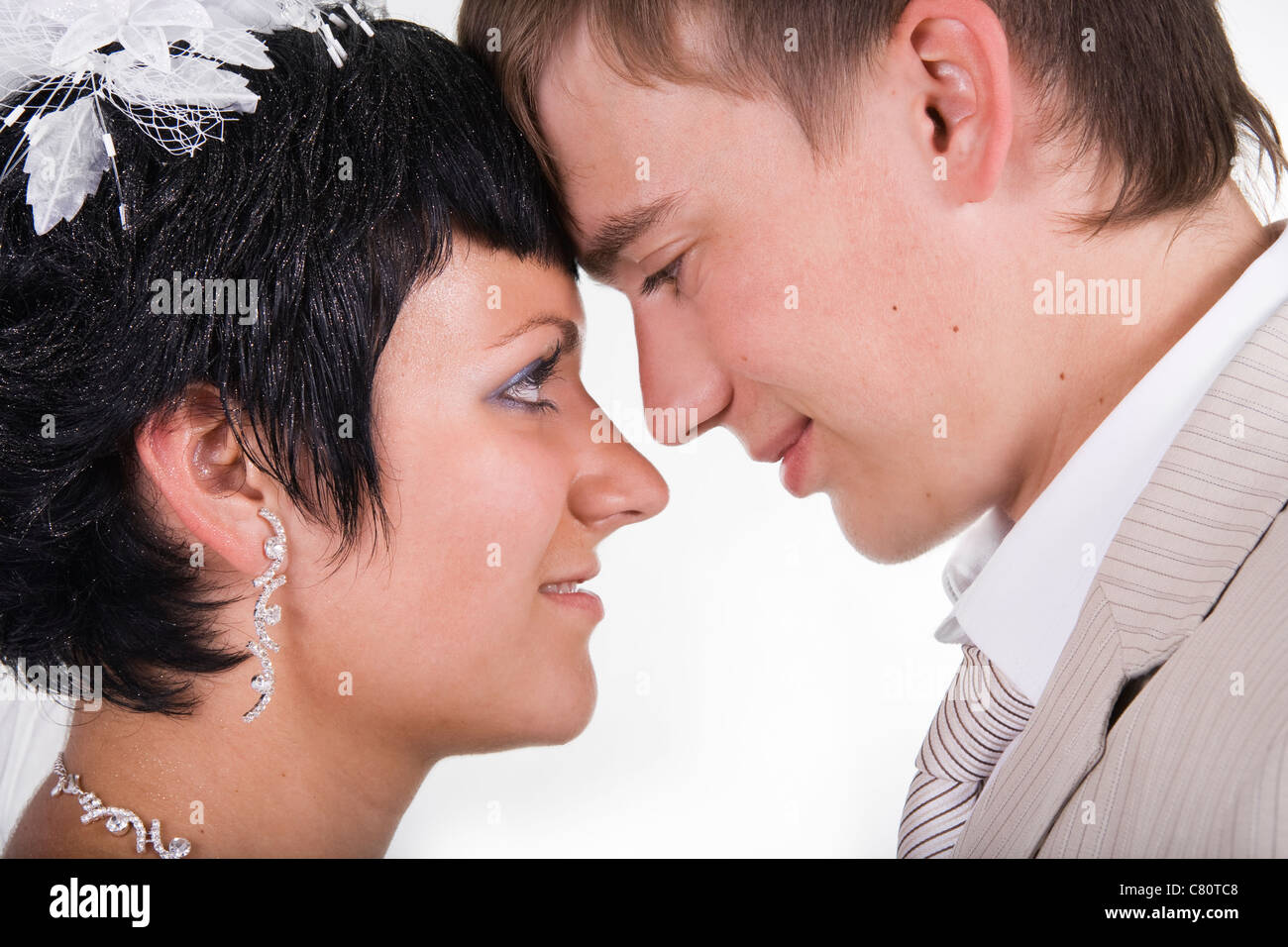 Schöne Braut und Bräutigam liebevolle sind glücklich miteinander. Einen weißen Hintergrund. Stockfoto