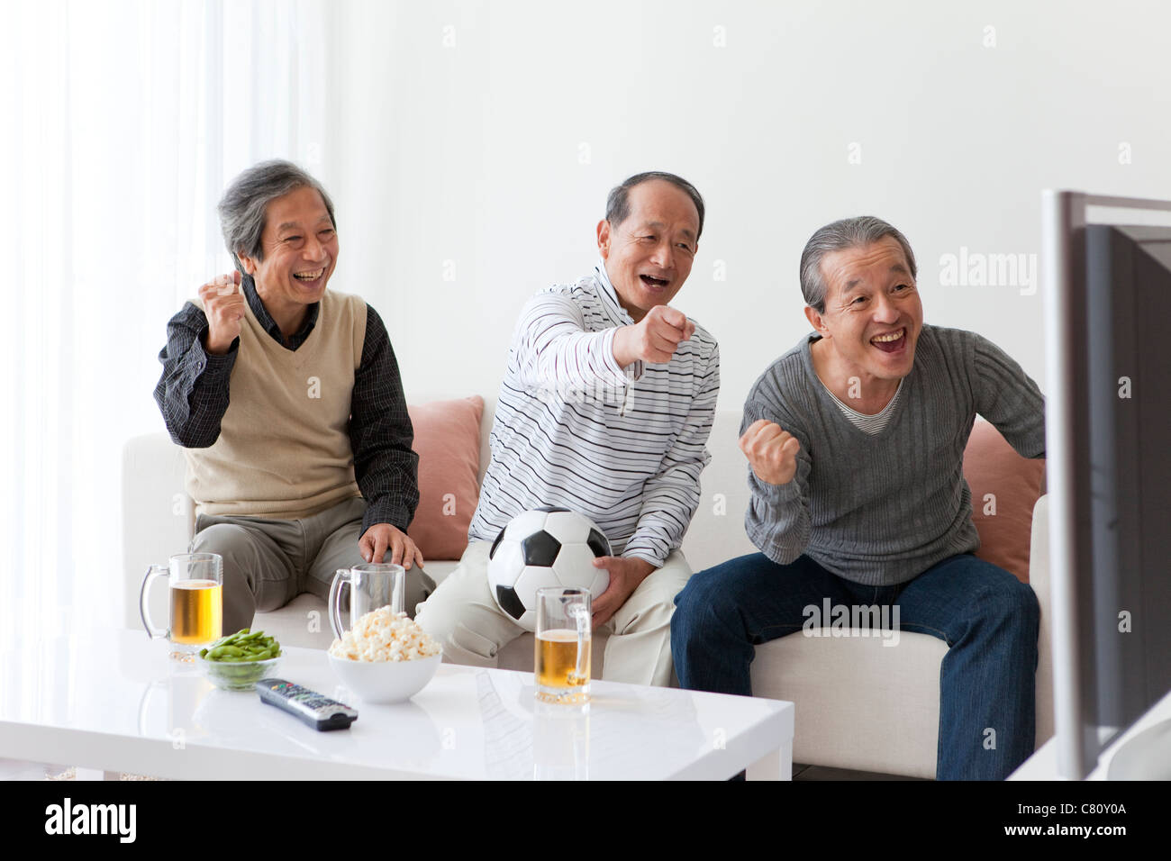 Ältere Männer beobachten Fußball Match vom TV Stockfoto