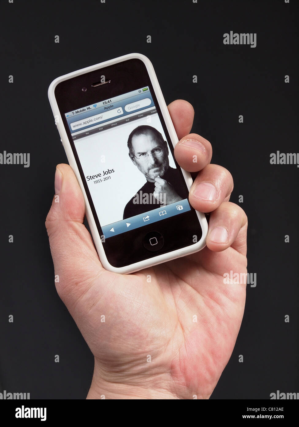 Homepage von Apple mit Steve Jobs in memoriam am Tag starb er, dargestellt auf einem iPhone 4 in der hand. Stockfoto