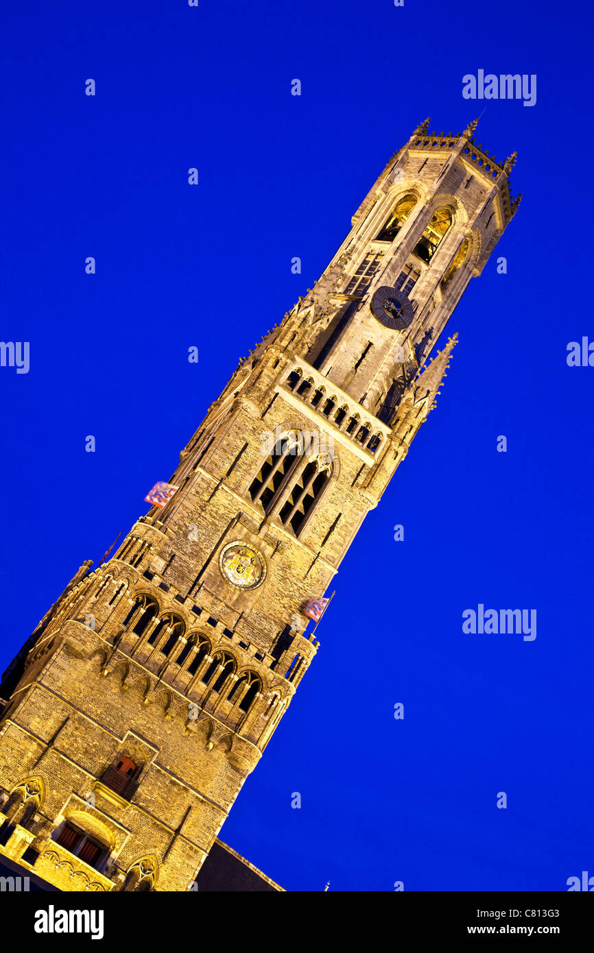 Die berühmte Ikone mittelalterliche Belfried oder Belfort mit Flutlicht in der Dämmerung in der Grote Markt, Brügge, Belgien Stockfoto