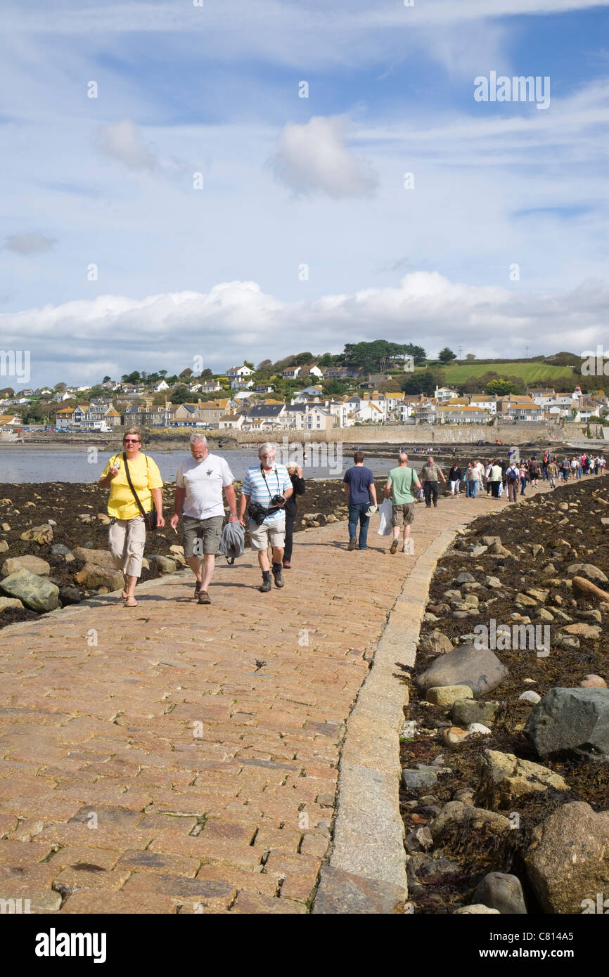 Besucher, die über den Damm nach St. Michaels Mount, Cornwall, England. Stockfoto