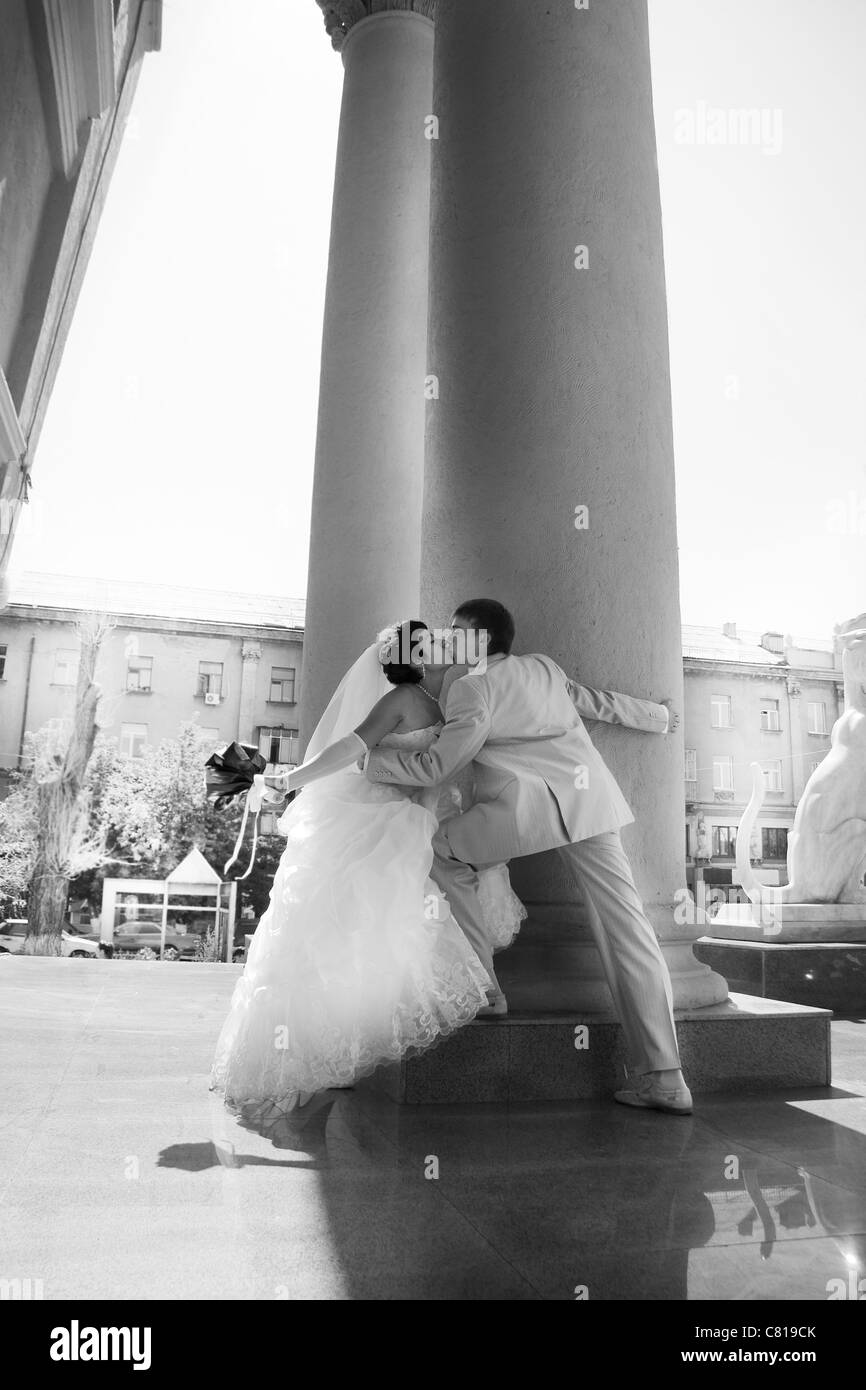 Braut und Bräutigam küssen sich in der Nähe von Hochzeitspalast Stockfoto