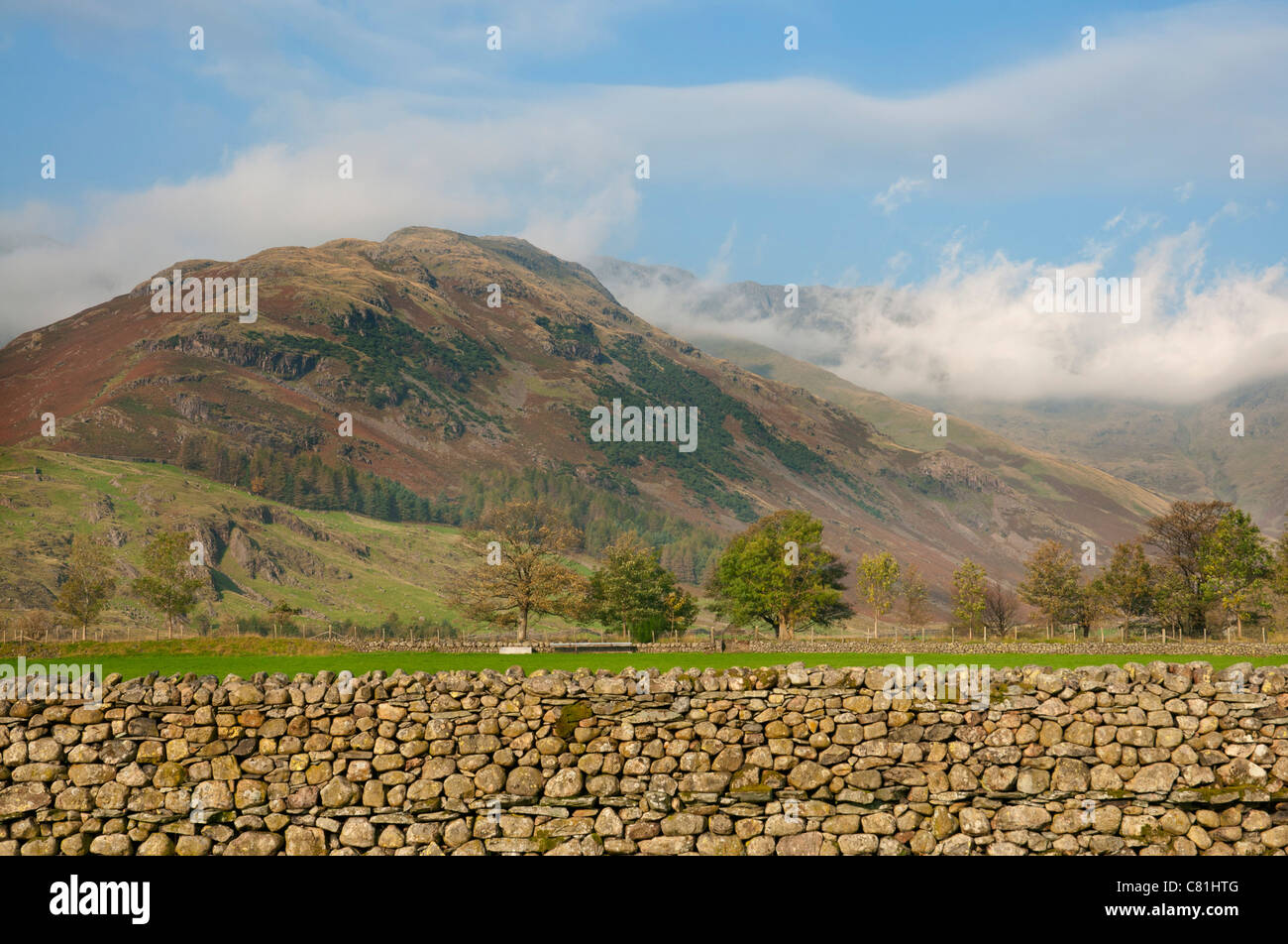 Trockenen Steinmauer im Lake District mit Hügeln im niedrigen Wolken im Hintergrund, Cumbria UK Stockfoto