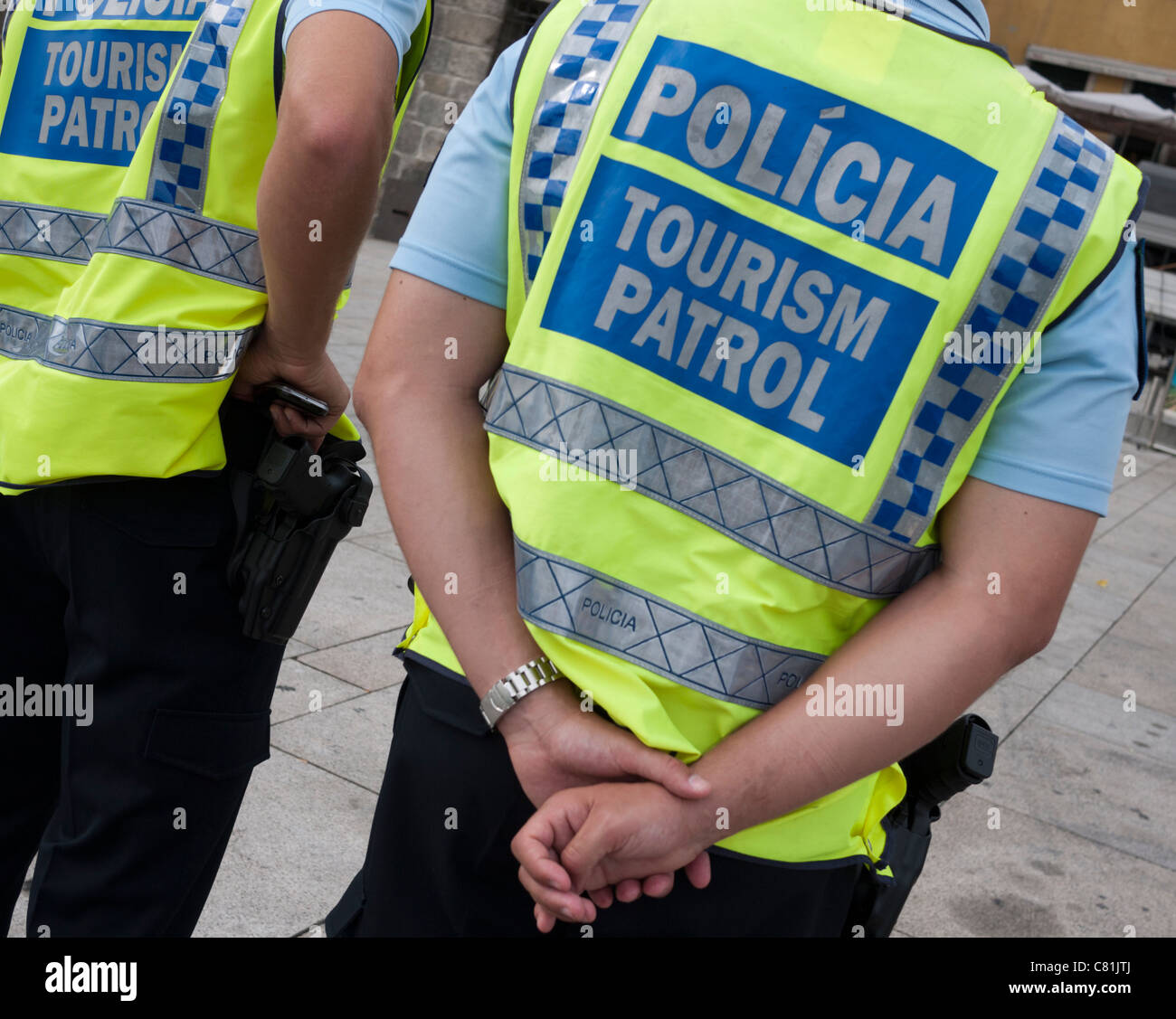 2 Tourismus Patrol Polizisten an der Uferpromenade in Porto, Portugal.  Sie tragen gelbe Jacken und Waffen zu tragen. Stockfoto