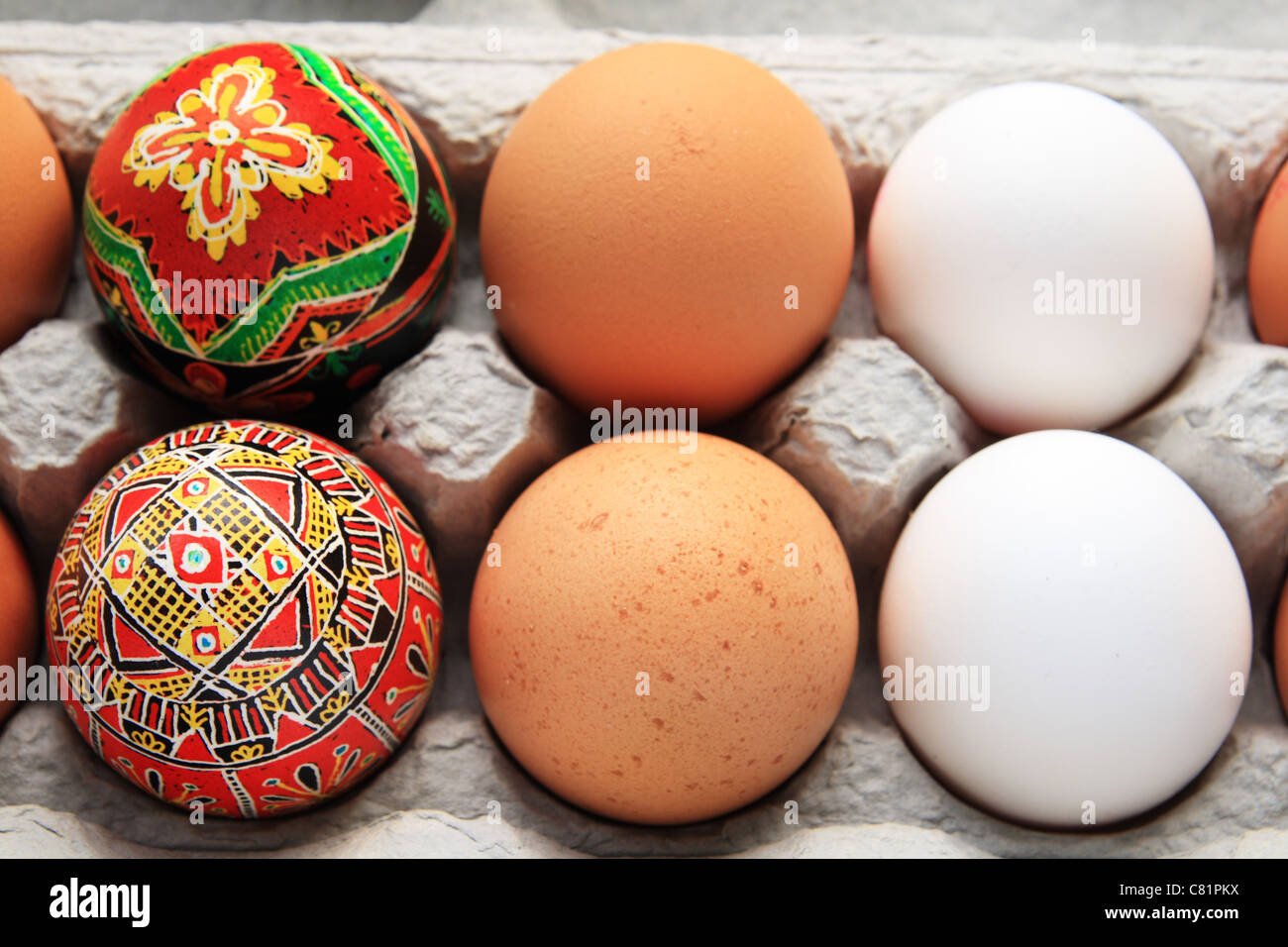 6 Eiern in einem Karton, inklusive 2 weiß, 2 braune und 2 rote Pysanka-Ostereier Stockfoto