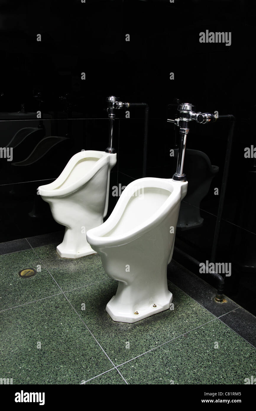 zwei alte Urinale in einem öffentlichen Mens Badezimmer Stockfoto