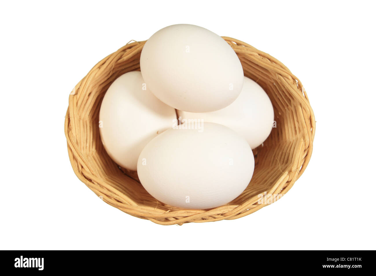 4 weißen Eiern in einen kleinen Weidenkorb isoliert auf weiss Stockfoto