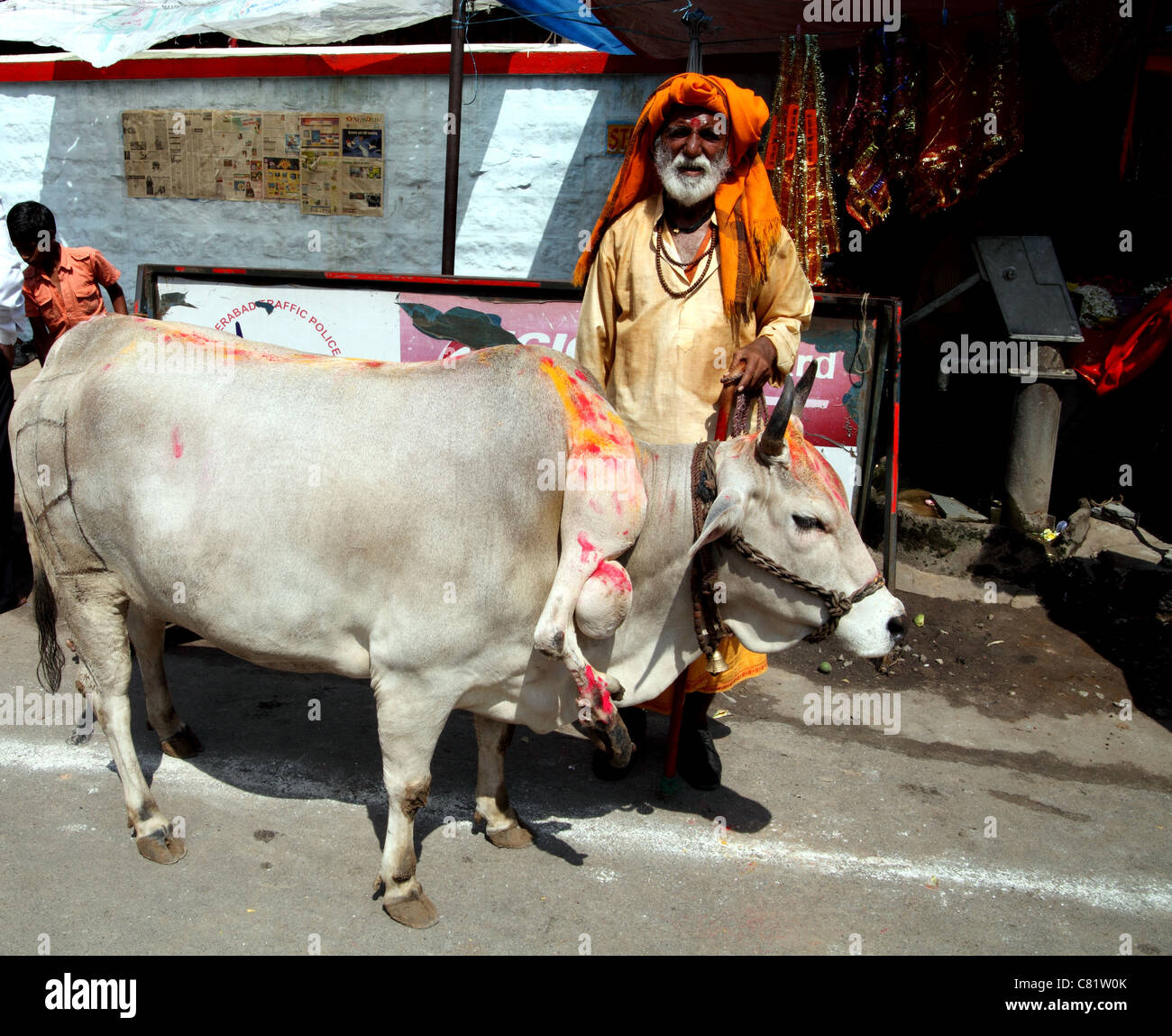 Heiliger Mann mit Heiligen fünfbeinige Kuh außerhalb Hindutempel, Hyderabad. Stockfoto