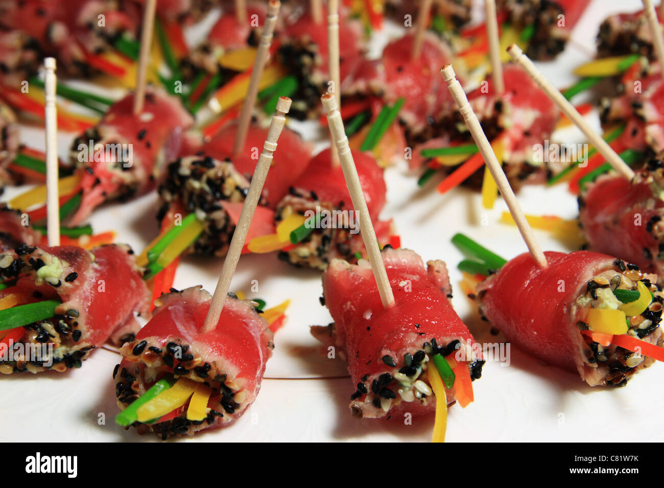 ein Teller mit gerollten Thunfisch Sushi am Zahnstocher Stockfoto