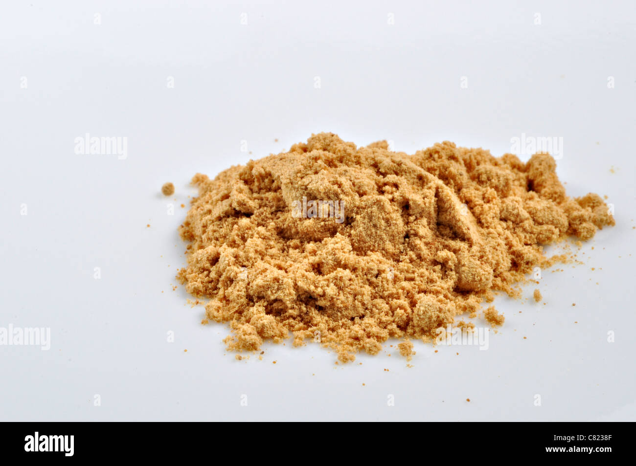 Ein kleiner Haufen von gemahlener Ingwer sitzt auf einem weißen Hintergrund. Stockfoto