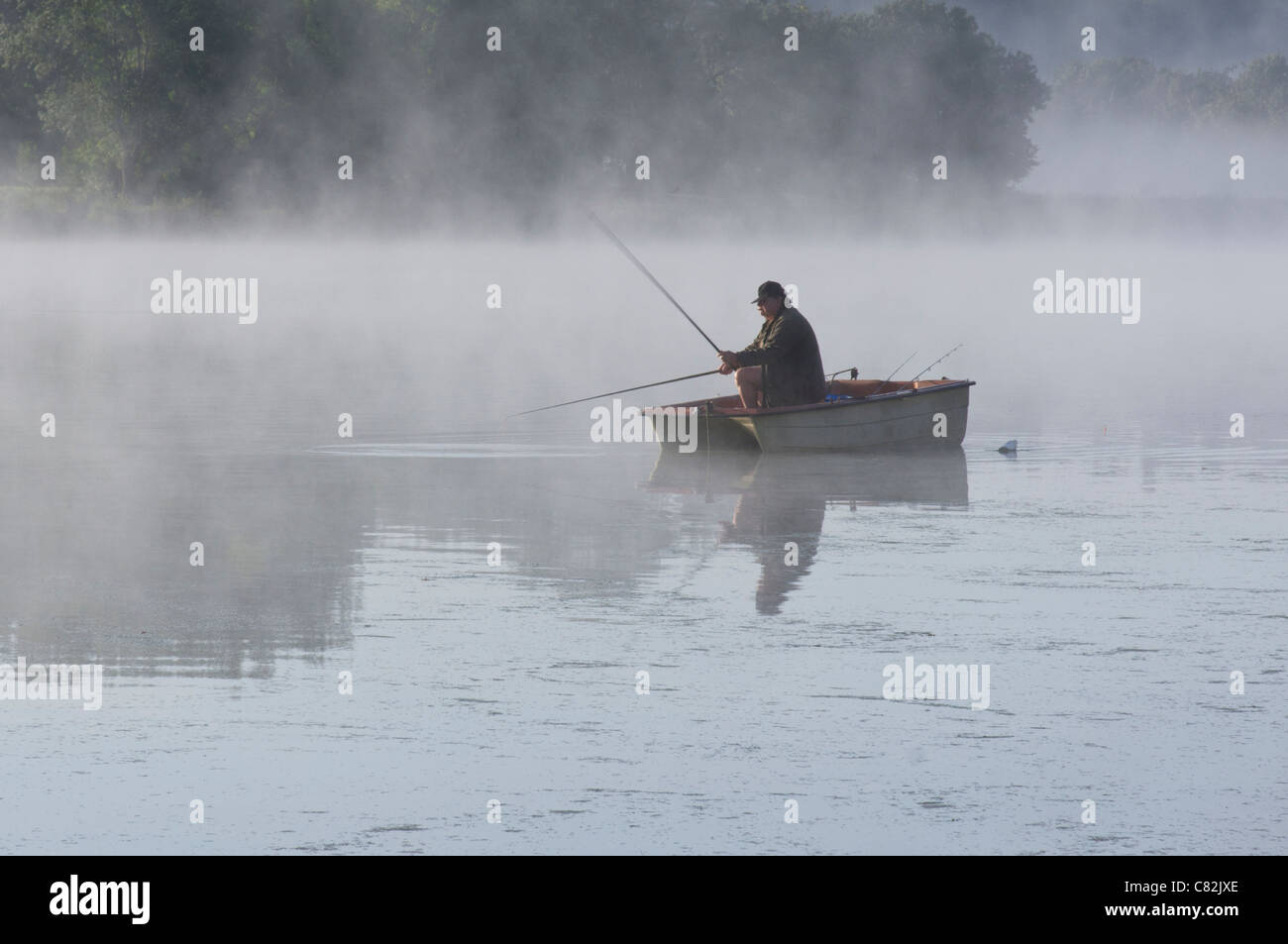 Angeln vom Boot in den frühen Morgennebel auf dem Fluss Saone in Frankreich Stockfoto