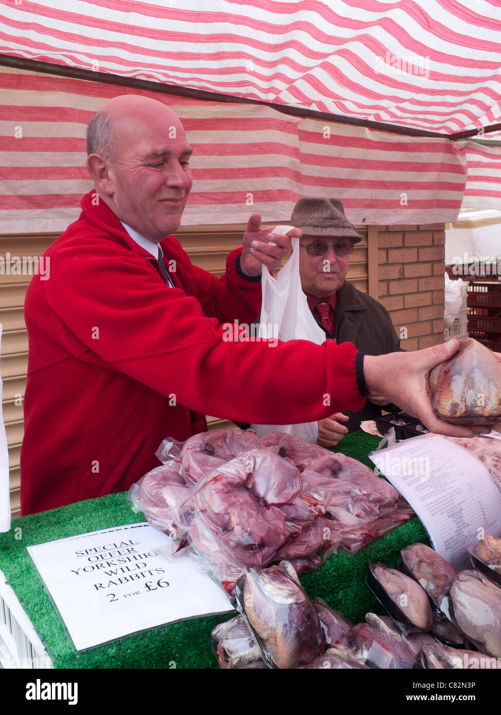 Metzger auf einem Bauernmarkt verkauft eine Klammer der Fasane Stockfoto