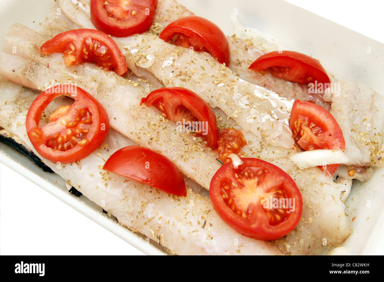 Pollock / Pollack Fischfilets in Schale zum Kochen, in Scheiben geschnittenen Tomaten & Kräuter (Alternative zu Kabeljau) Stockfoto