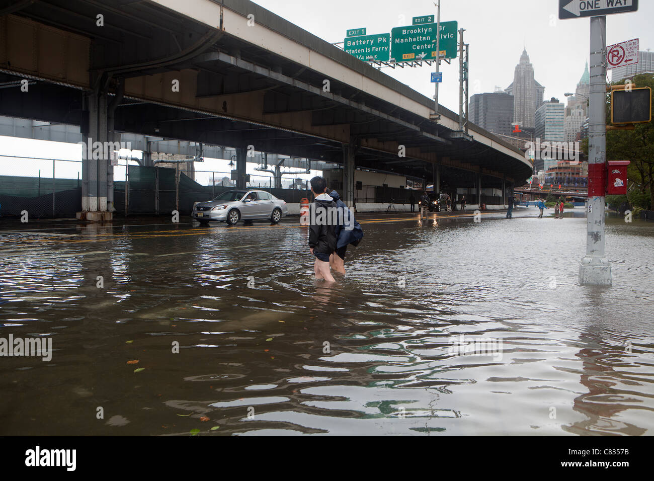 Überflutete Straße unter Manhattan Bridge in New York City, während Hurricane Irene. Person vorbei Stockfoto