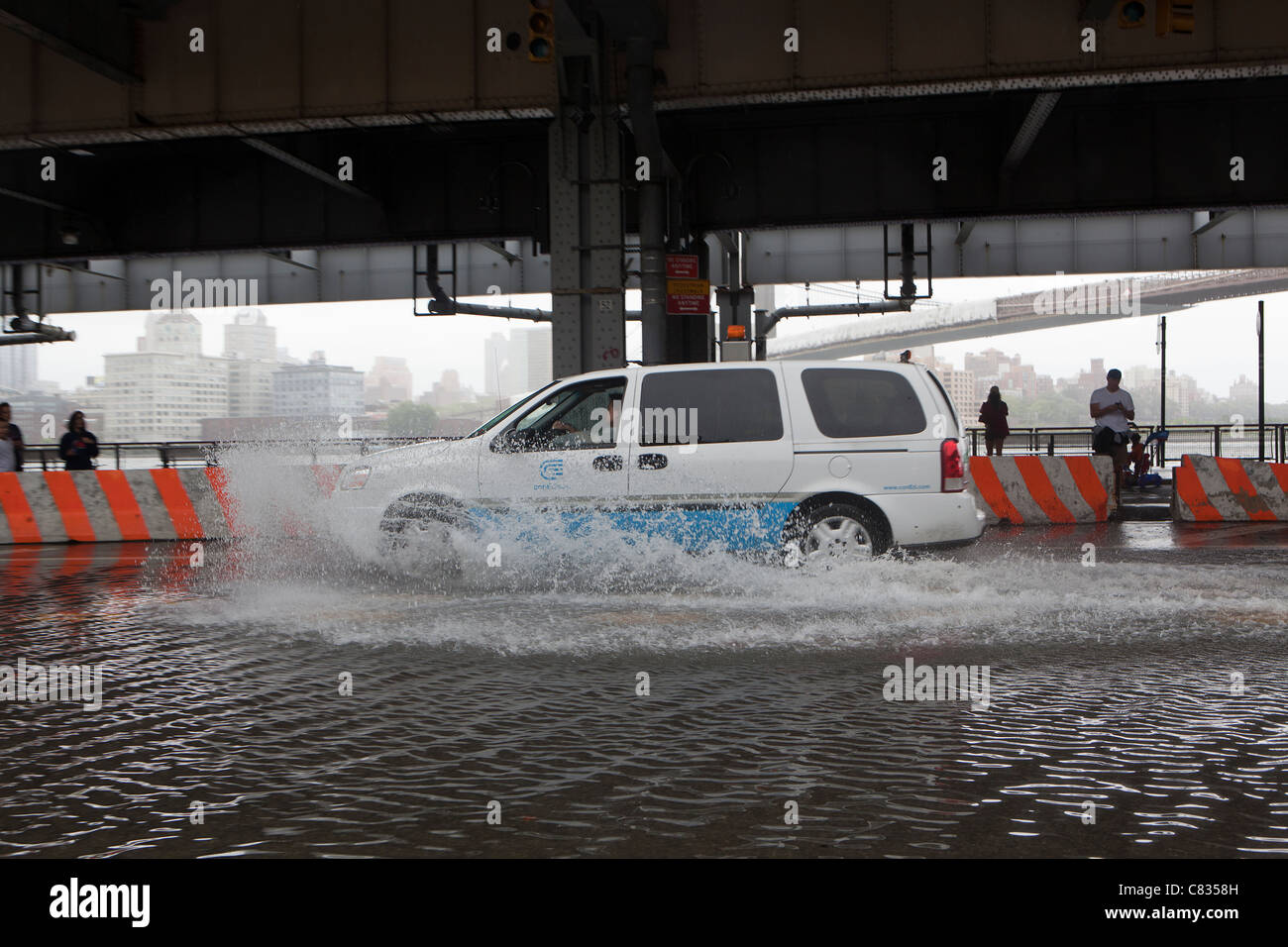 Überflutete Straße unter Manhattan Bridge in New York City, während Hurricane Irene. Auto vorbei. New York. USA Stockfoto
