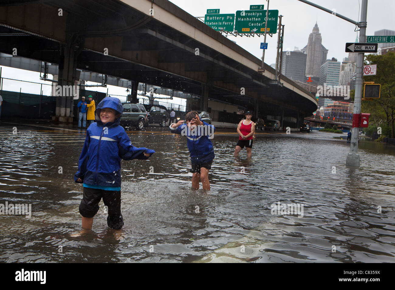 Überflutete Straße unter Manhattan Bridge in New York City, während Hurricane Irene. Kinder mit Wasser spielen. New York City, USA Stockfoto