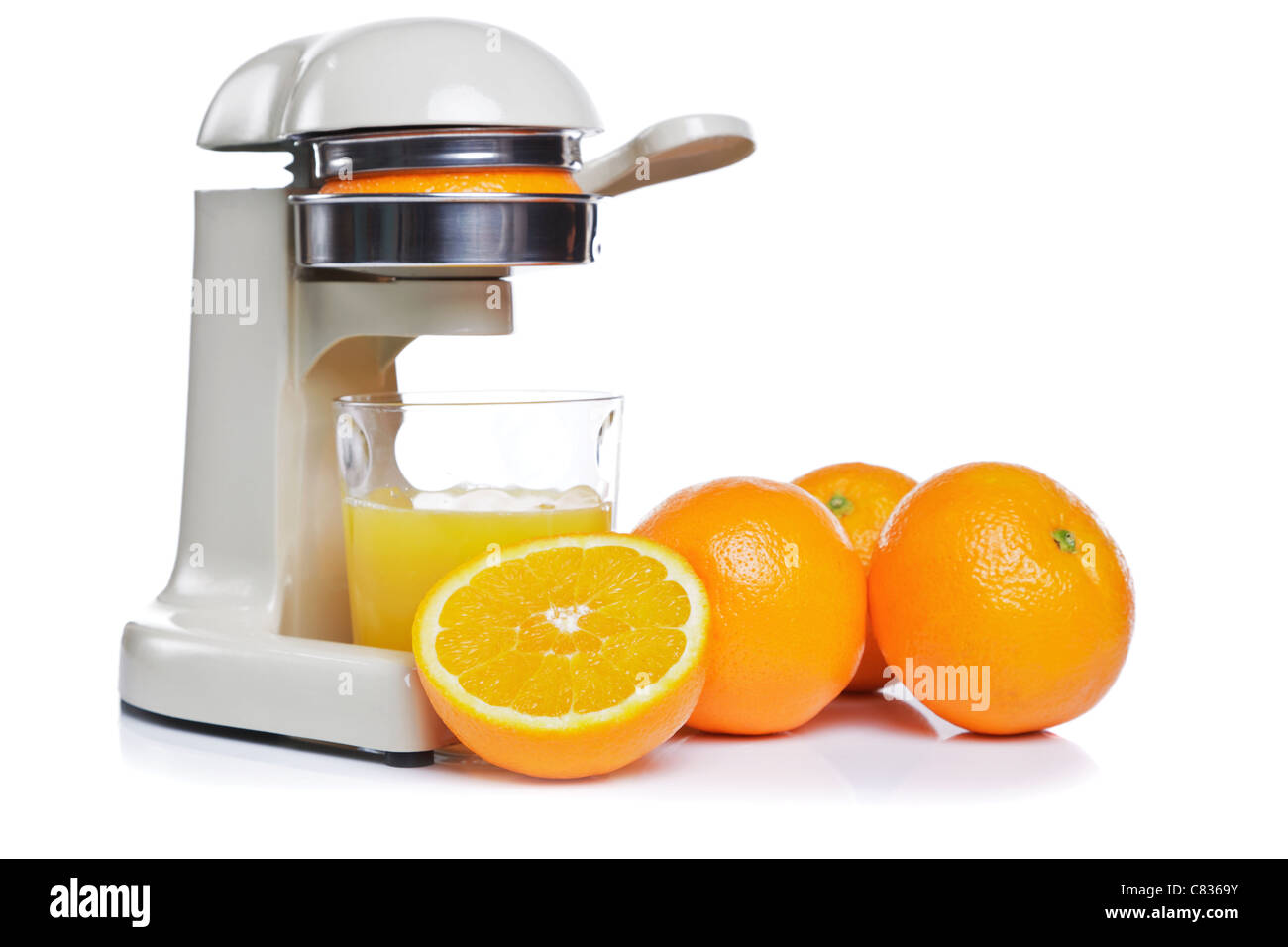 Foto von einem Entsafter und ein Glas frisch gepressten Orangensaft, isoliert auf einem weißen Hintergrund. Stockfoto