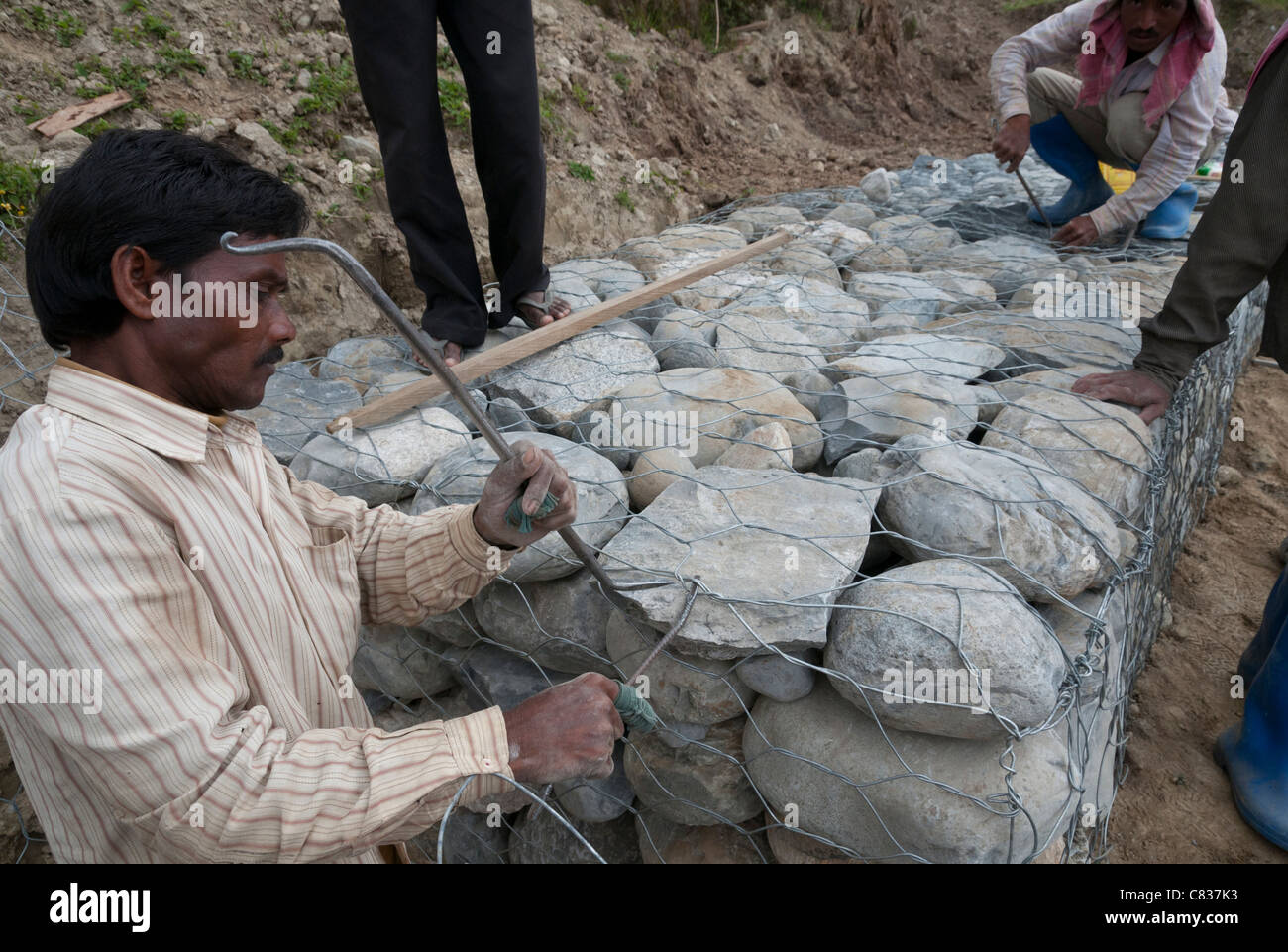 Indische Arbeiter auf der Baustelle des Landes Schiebe-Prävention Steinmauern. Radi. Ost Bhutan Stockfoto