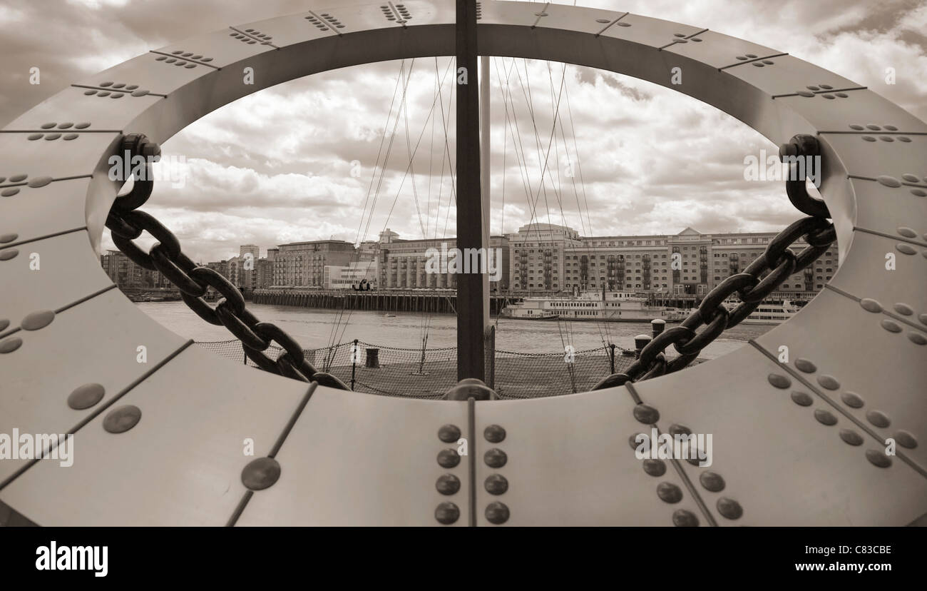 Die Sonnenuhr im St. Katherine's Dock umrahmen die Ansicht des Butlers Wharf über die Themse, London, UK. Stockfoto