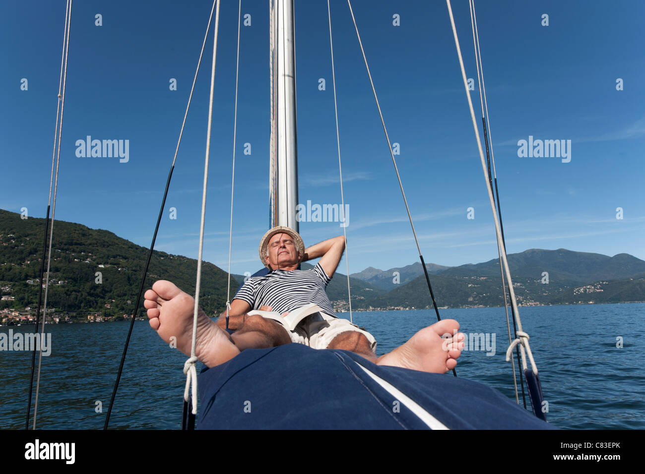 Älterer Mann entspannend auf Segelboot Stockfoto