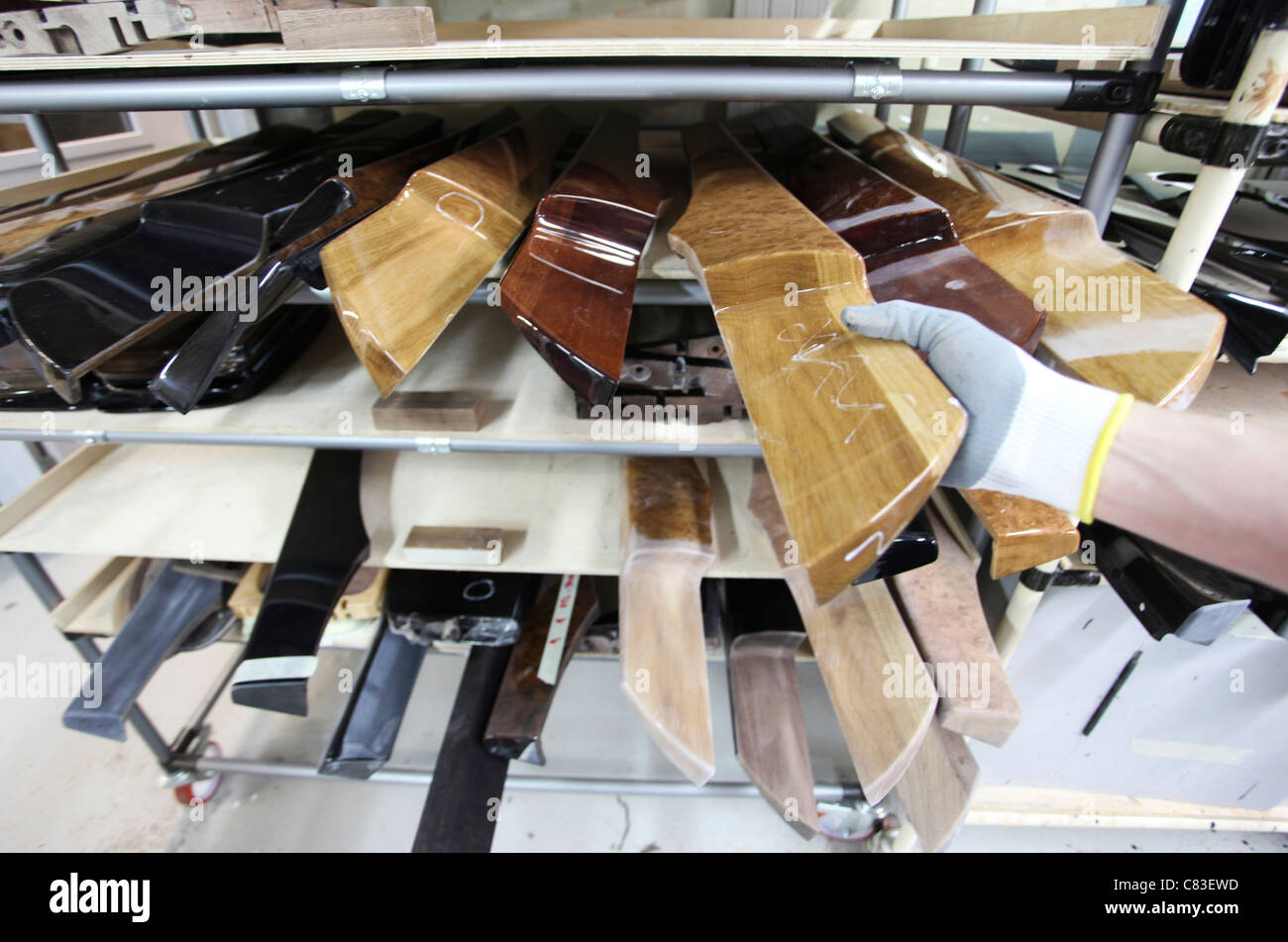Ein Mitarbeiter nimmt eine innere Holzteil für ein Bentley Auto des Unternehmens Werk in Crewe, Großbritannien Stockfoto