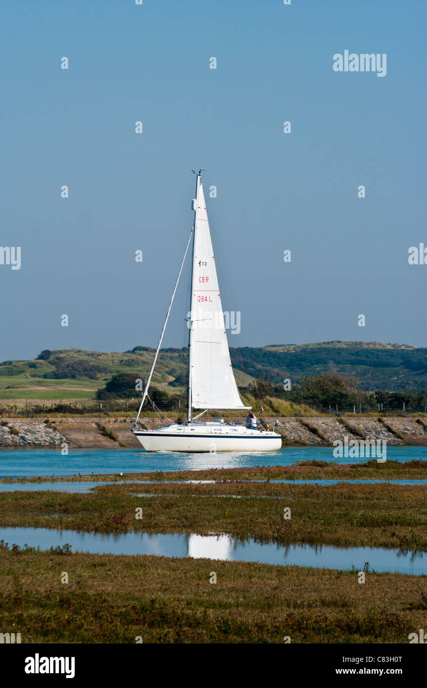 Seitenansicht des A Sailing Yacht mit Crew Cruising Up The River Rother Roggen Hafen Sussex Ostengland Sonnenschein, blauer Himmel Stockfoto