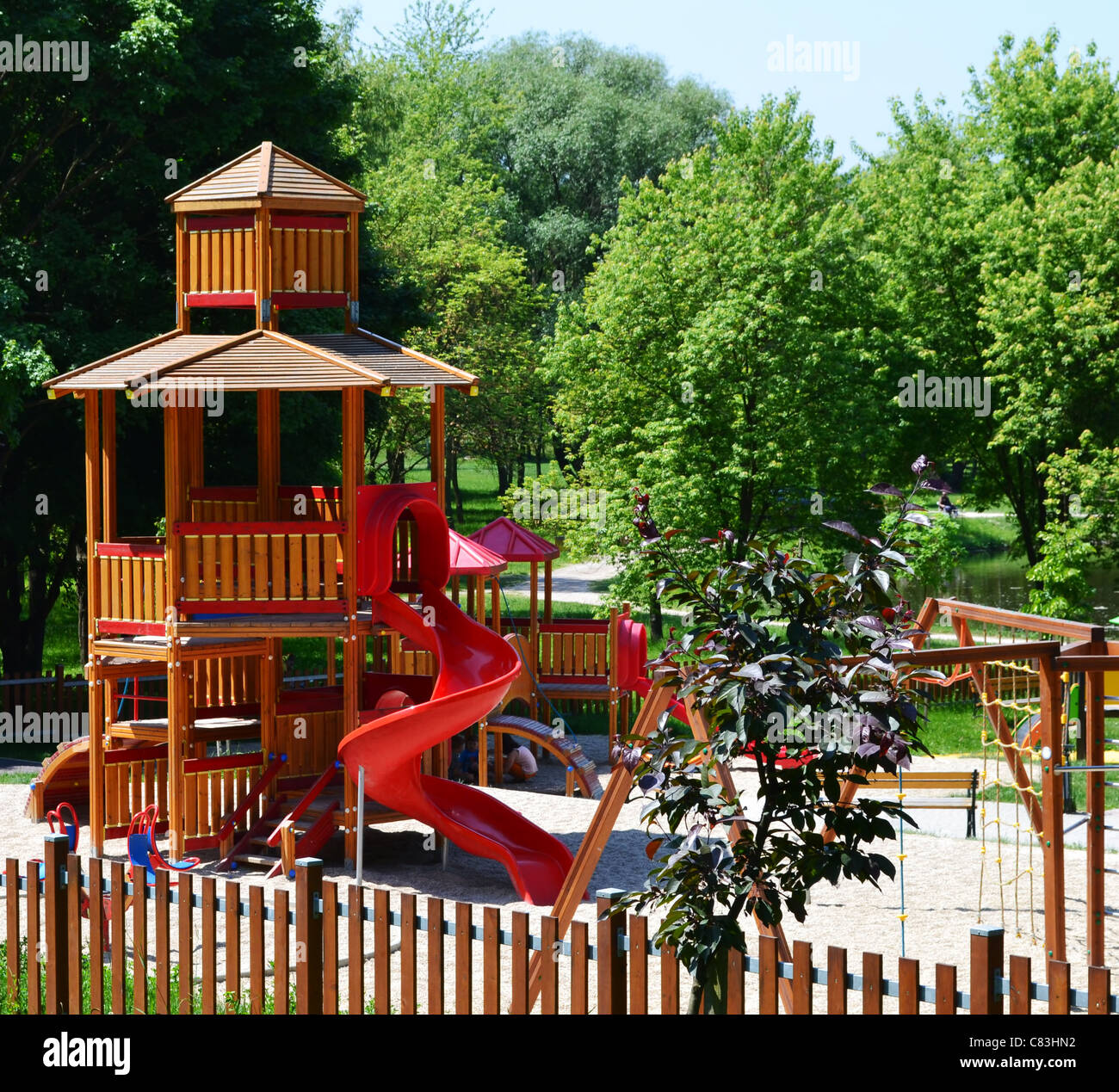 Hölzerne Burg mit Rutsche auf einem modernen Spielplatz befindet sich in einem Freizeitpark - eine natürliche, gesunde Umgebung für Kinder. Stockfoto