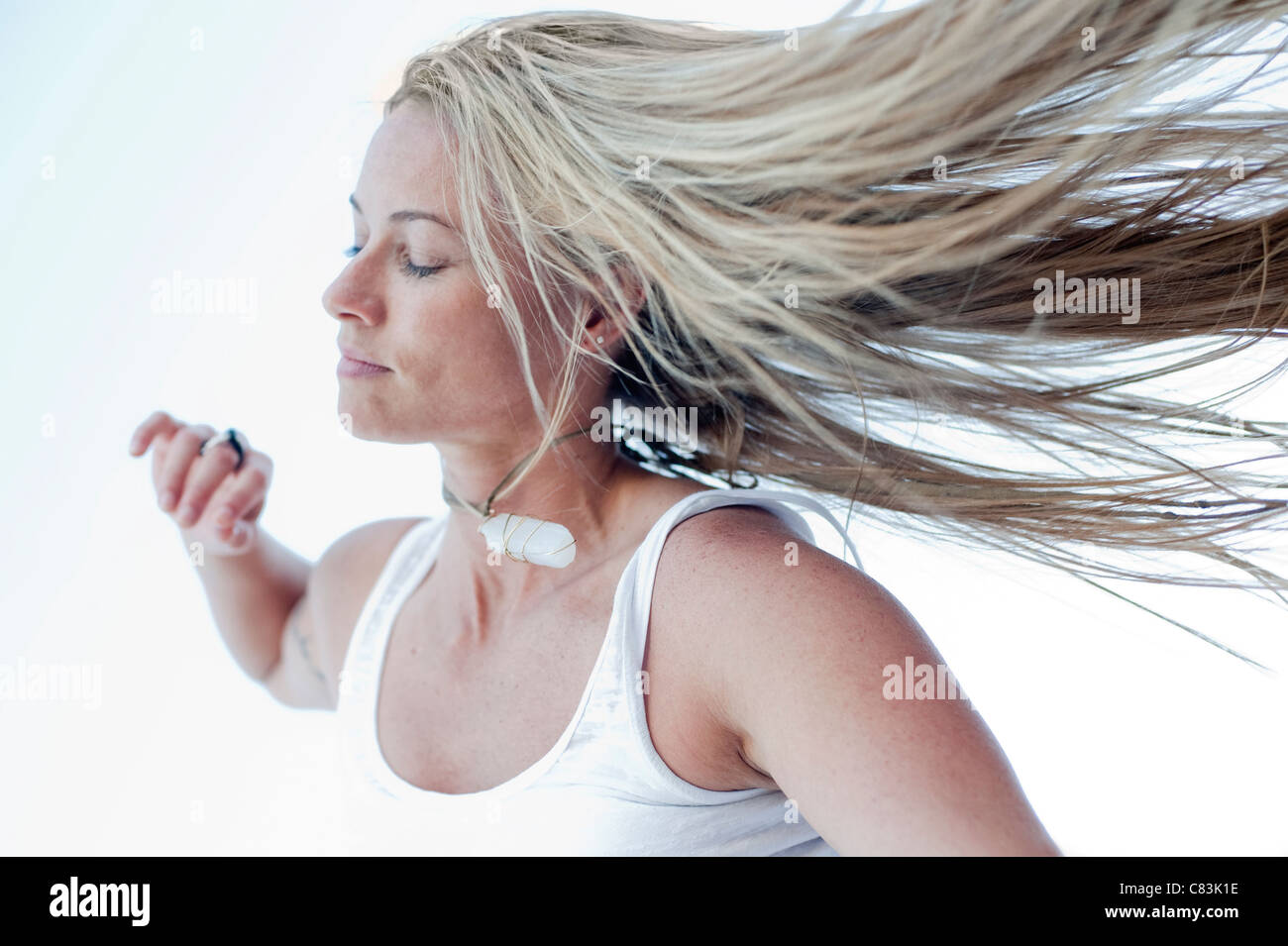 Porträt von eine schöne langhaarige blonde Frau durch den offenen Raum bewegen. Stockfoto