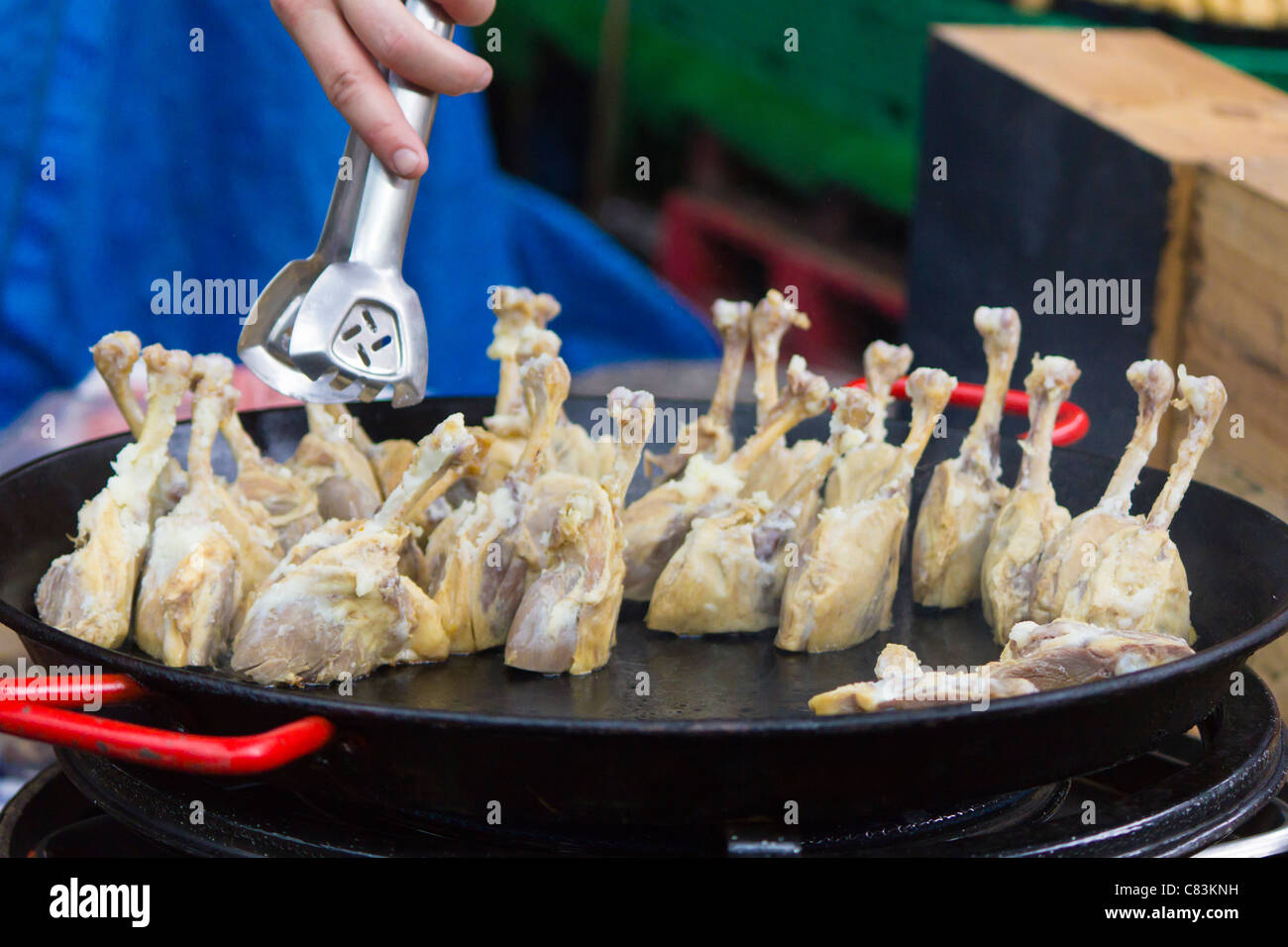 Koch bereitet Huhn an einem Marktstand in Borough Market. Stockfoto