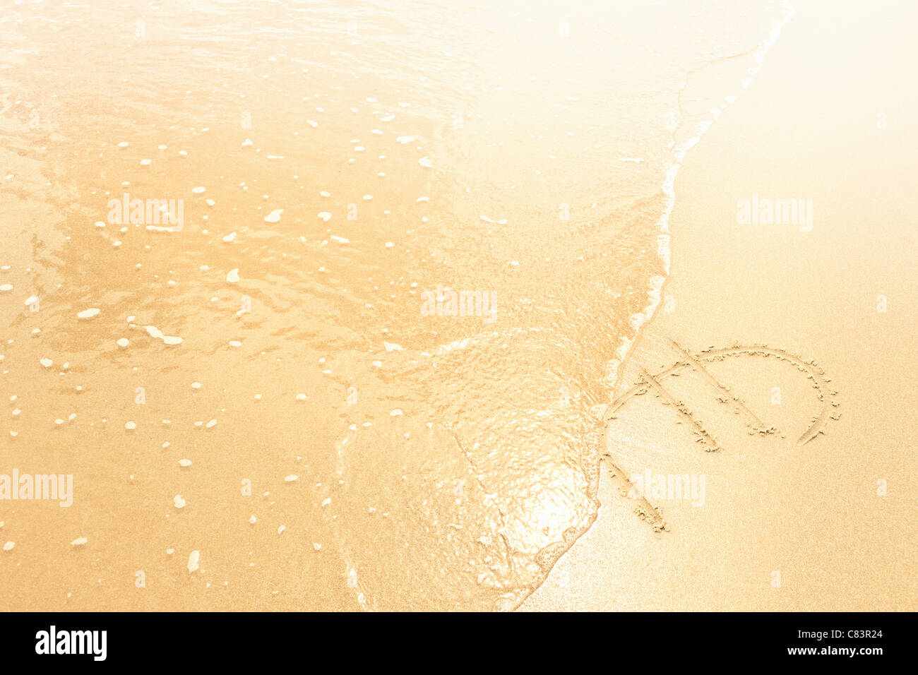 Euro-Symbol im Sand von Wellen weggespült Stockfoto