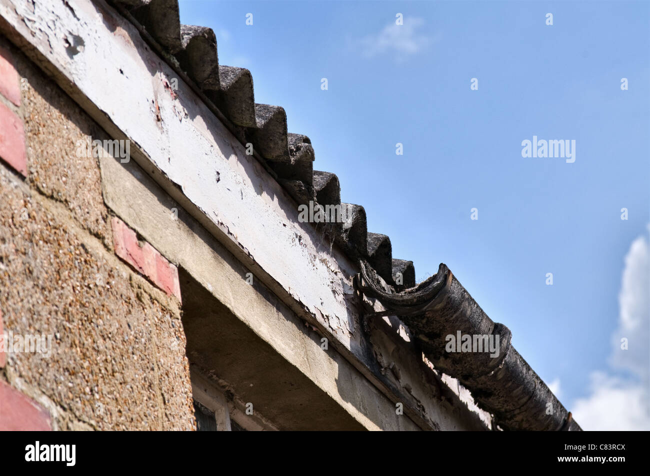 Alten gebrochen Asbest Gosse und Wellpappe Dach Blätter. Blick von der Seite. Nahaufnahme Stockfoto