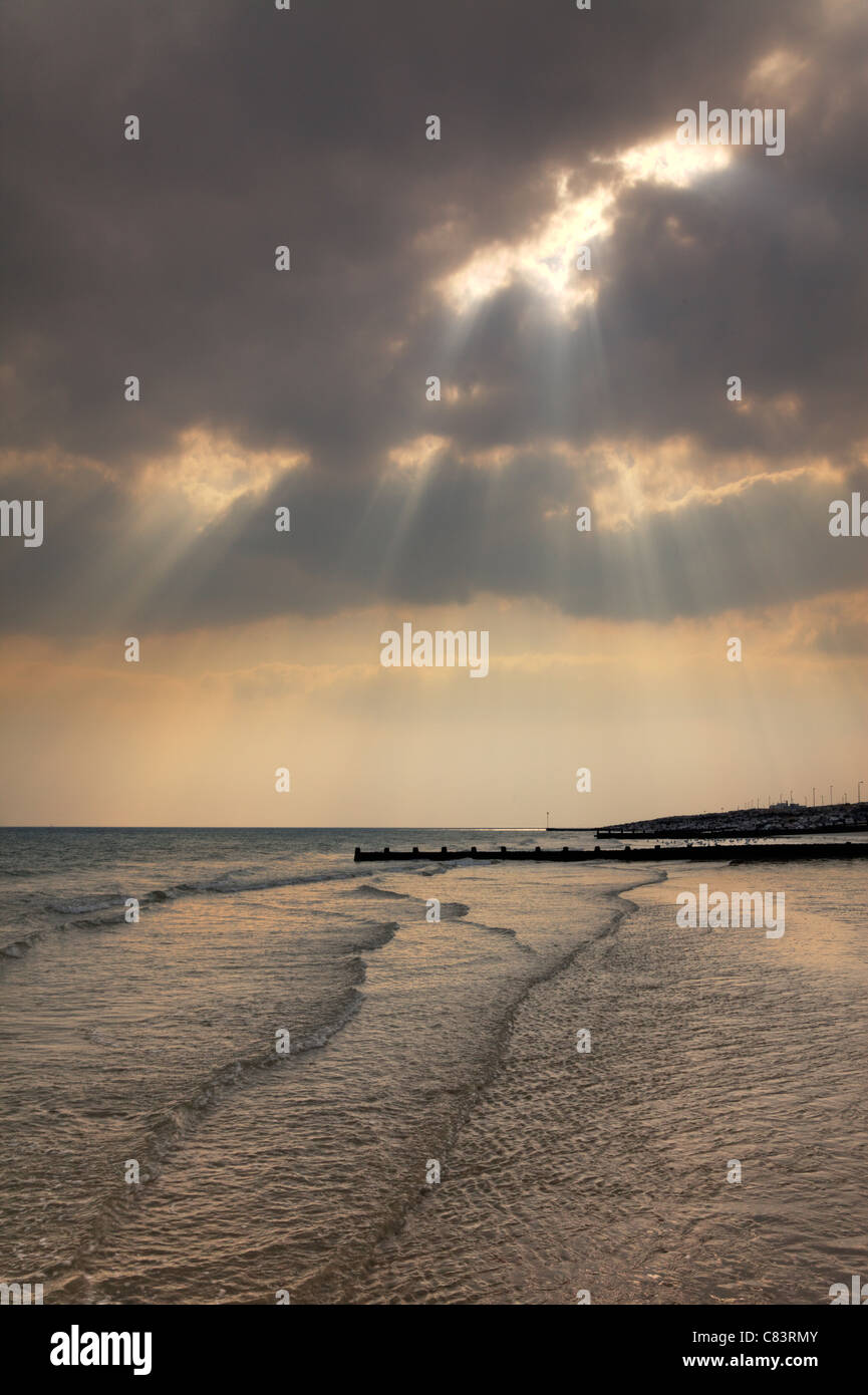 Sonnenstrahlen durch die Wolken, Küste von Worthing, West Sussex Stockfoto