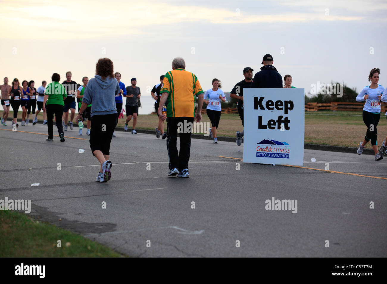 Halten Sie linke Zeichen, Läufer und Walker in der Goodlife Fitness Marathon in Victoria BC Kanada zu lenken Stockfoto