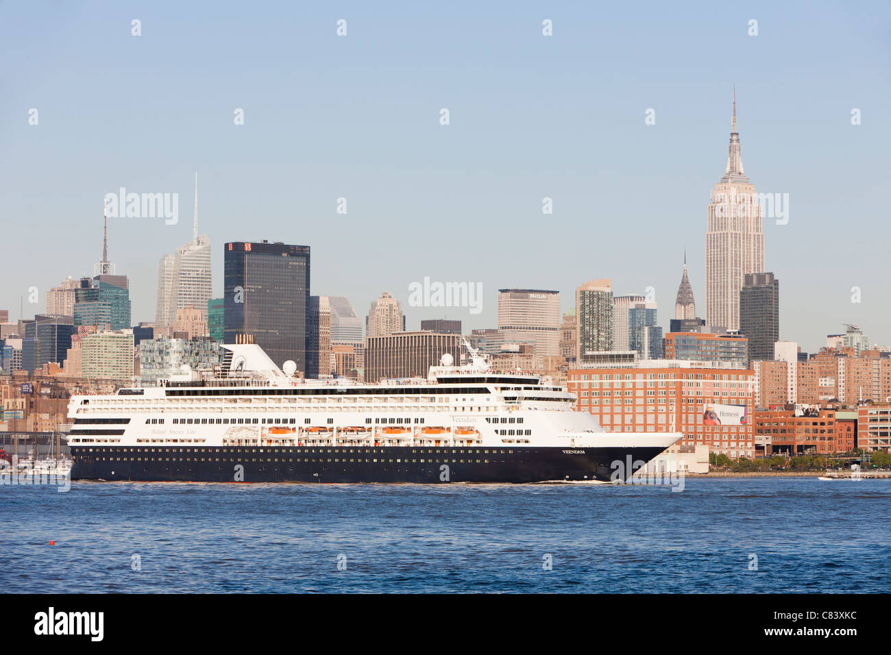 Holland America Line Kreuzfahrtschiff M/S Veendam Köpfe Süd auf dem Hudson River, vorbei an der Skyline von Mid-Town in New York City. Stockfoto