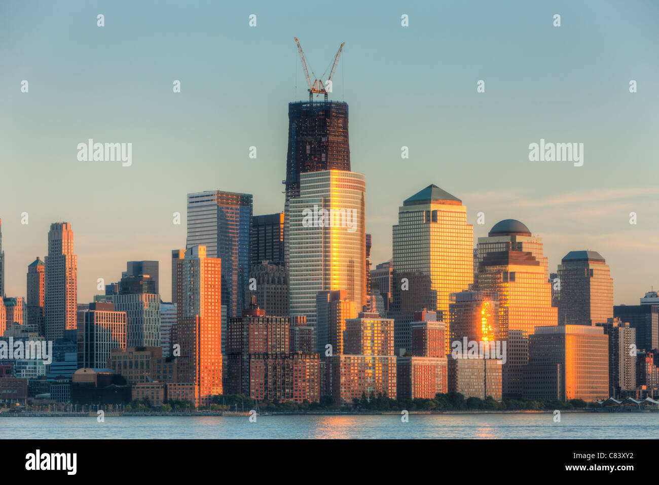 Der Sonnenuntergang Himmel gefärbt wird von Gebäuden in lower Manhattan, einschließlich der World Financial Center und Battery Park City reflektiert. Stockfoto