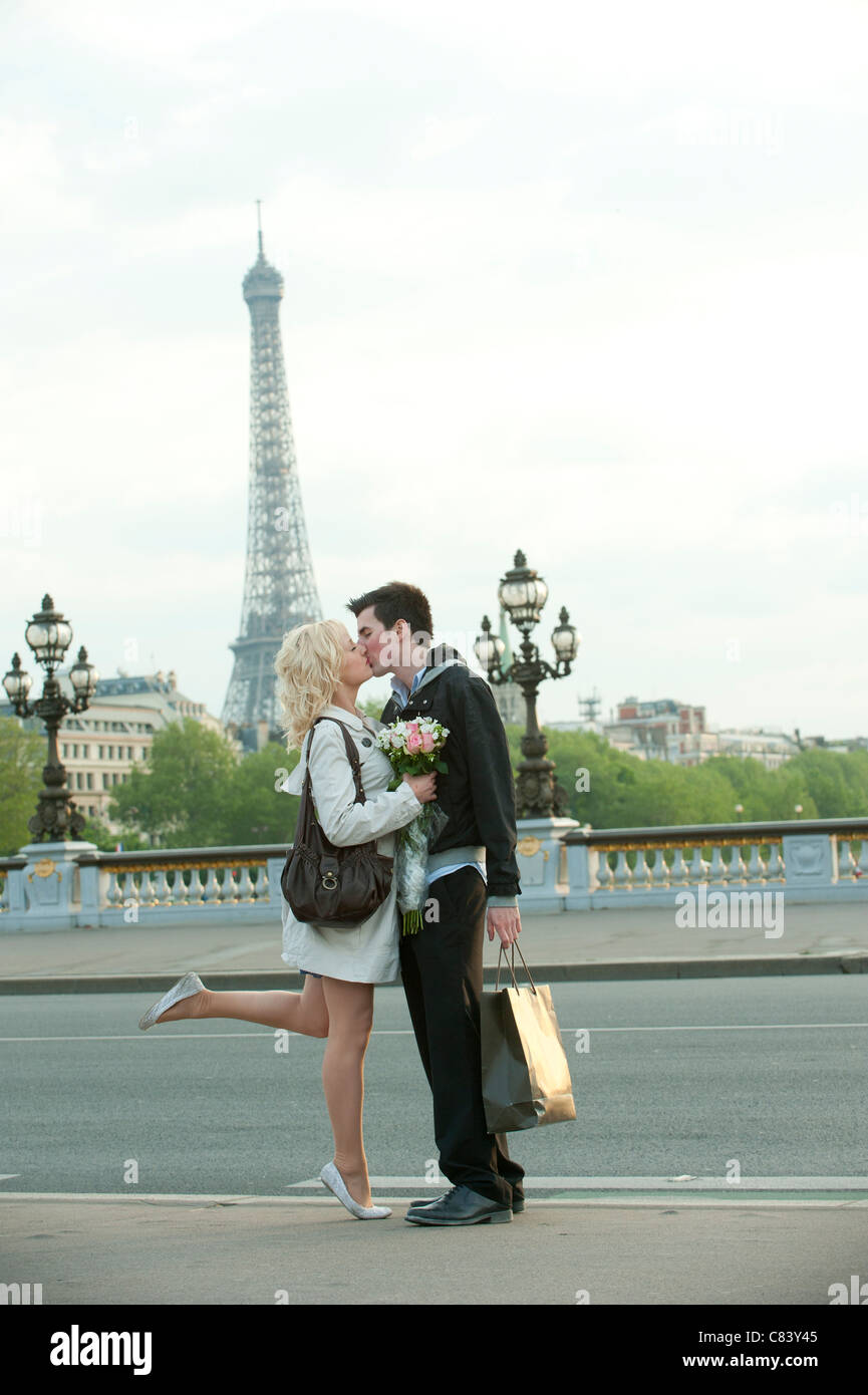 Kaukasische paar Küssen auf Brücke mit Eiffelturm im Hintergrund Stockfoto