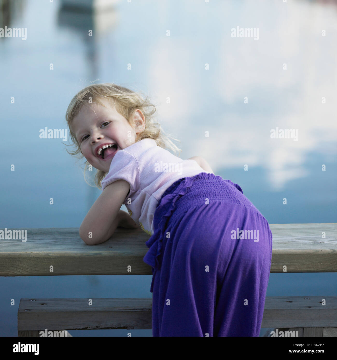 Mädchen beugte sich über Geländer Pier Stockfoto