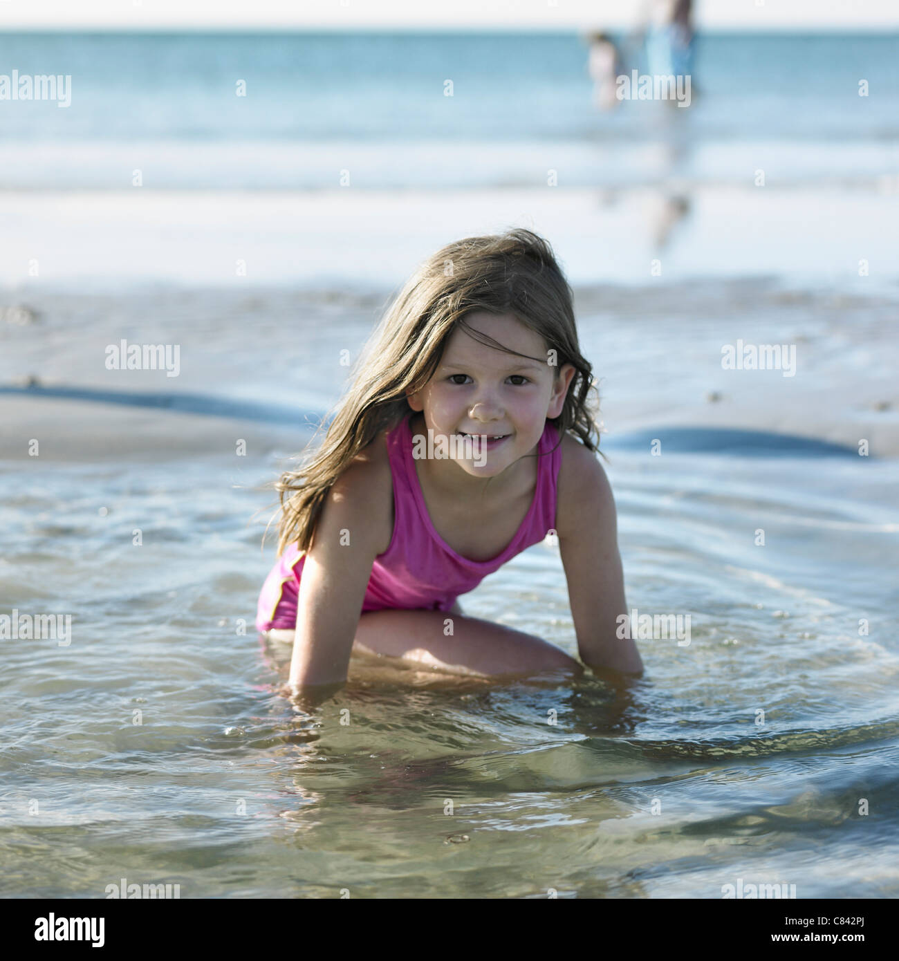 Mädchen spielen im Wasser am Strand Stockfoto