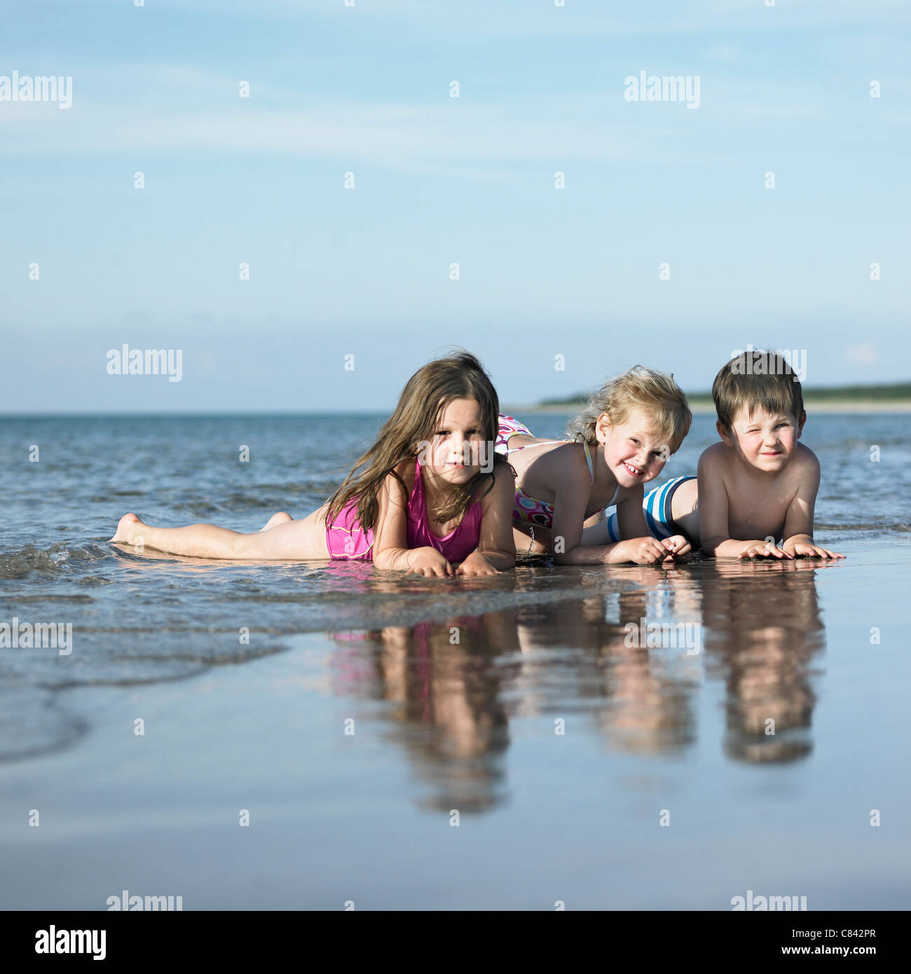 Kinder spielen in den Wellen am Strand Stockfoto