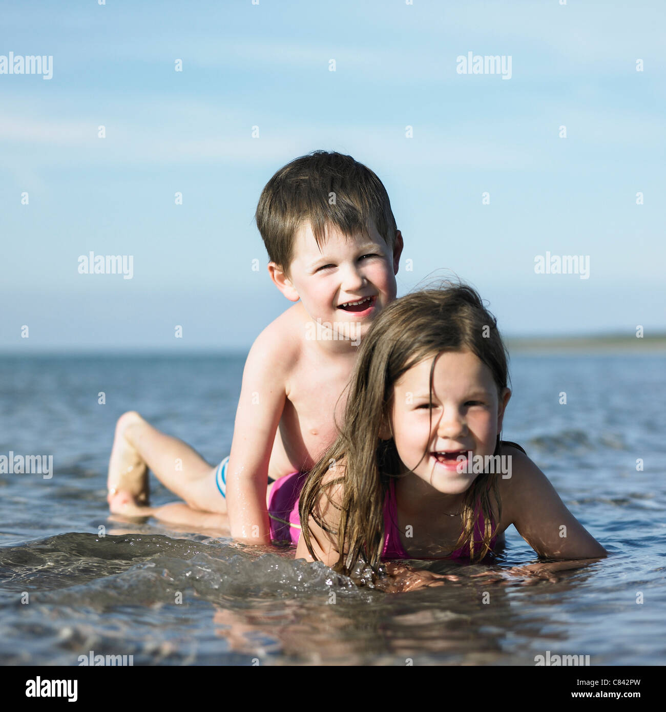 Kinder spielen in den Wellen am Strand Stockfoto