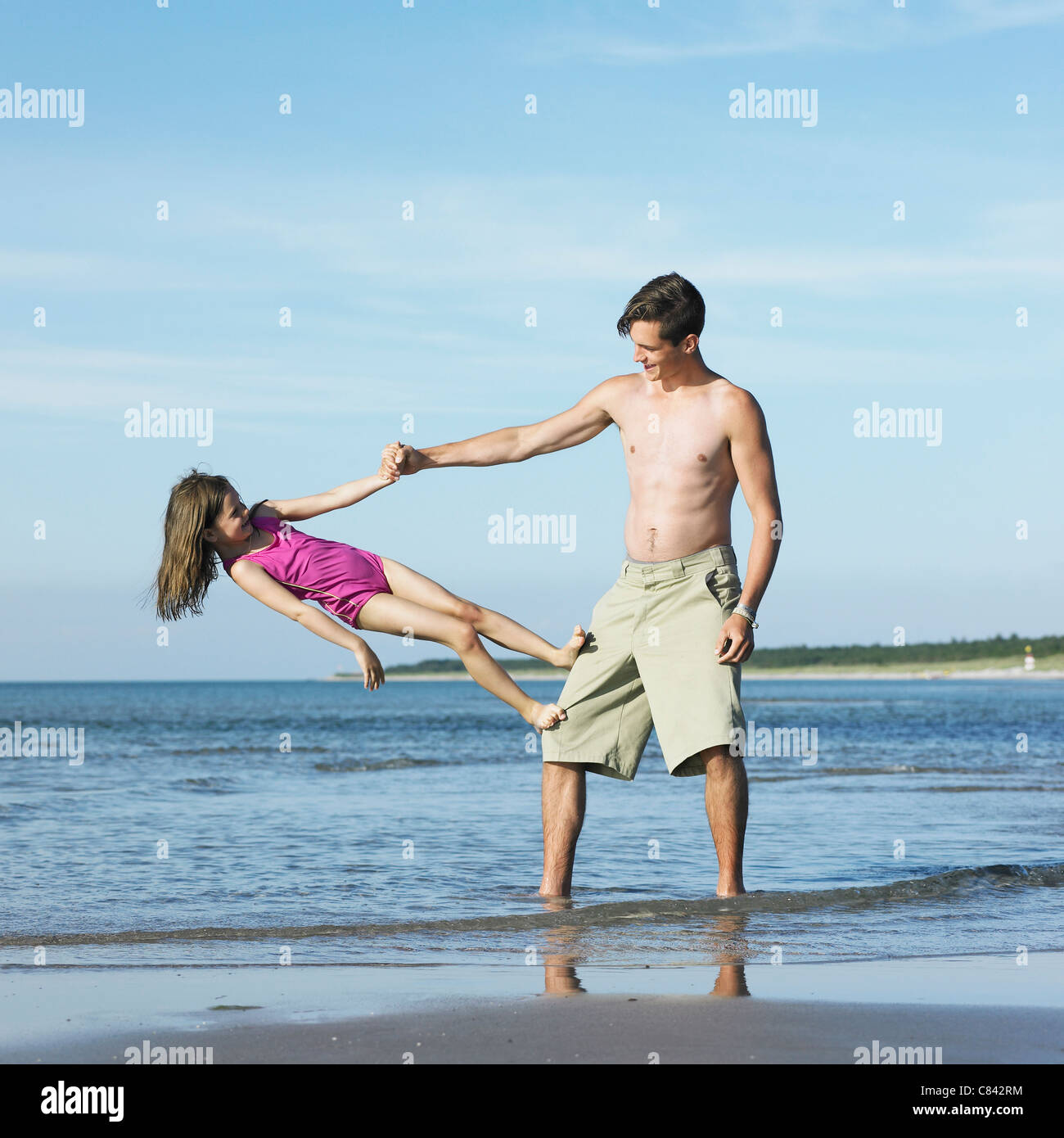 Bruder und Schwester spielen am Strand Stockfoto
