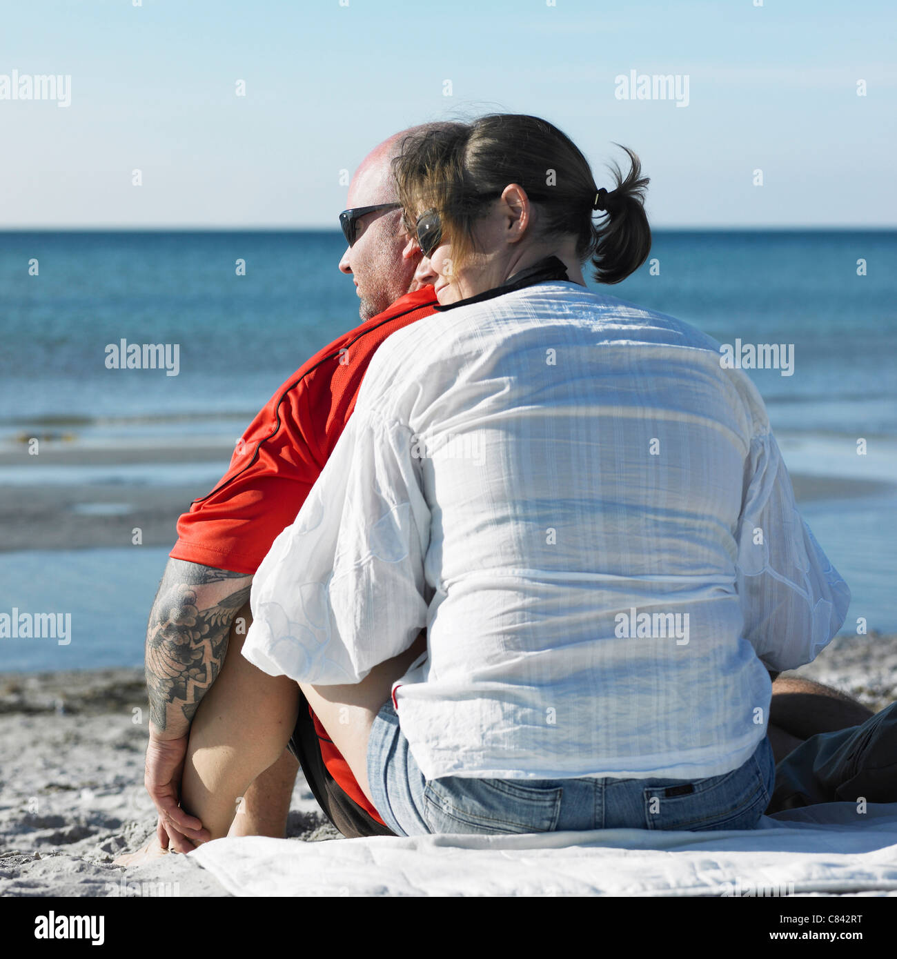Paar am Strand umarmt Stockfoto