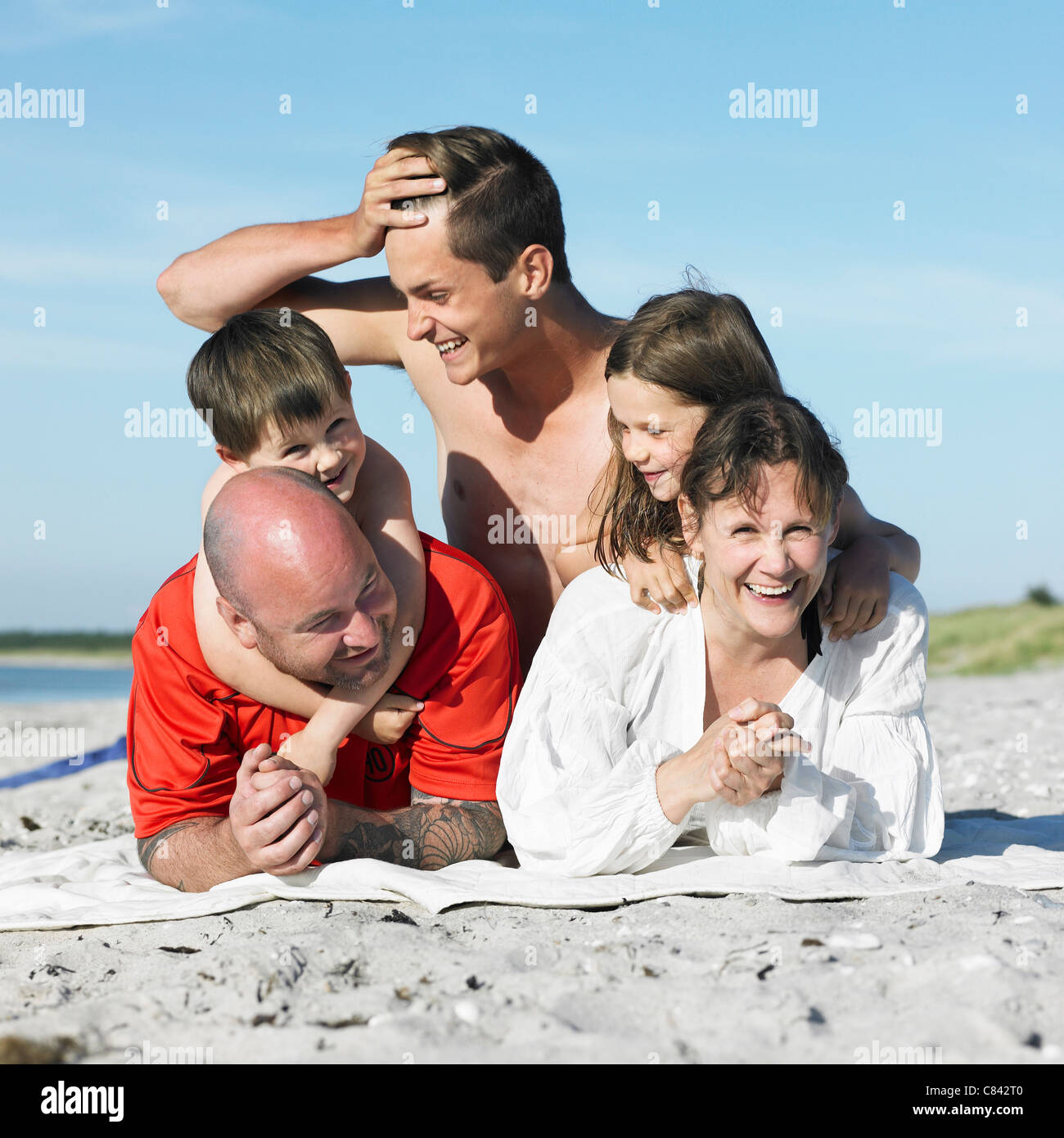 Familie Handauflegen Strandtuch zusammen Stockfoto