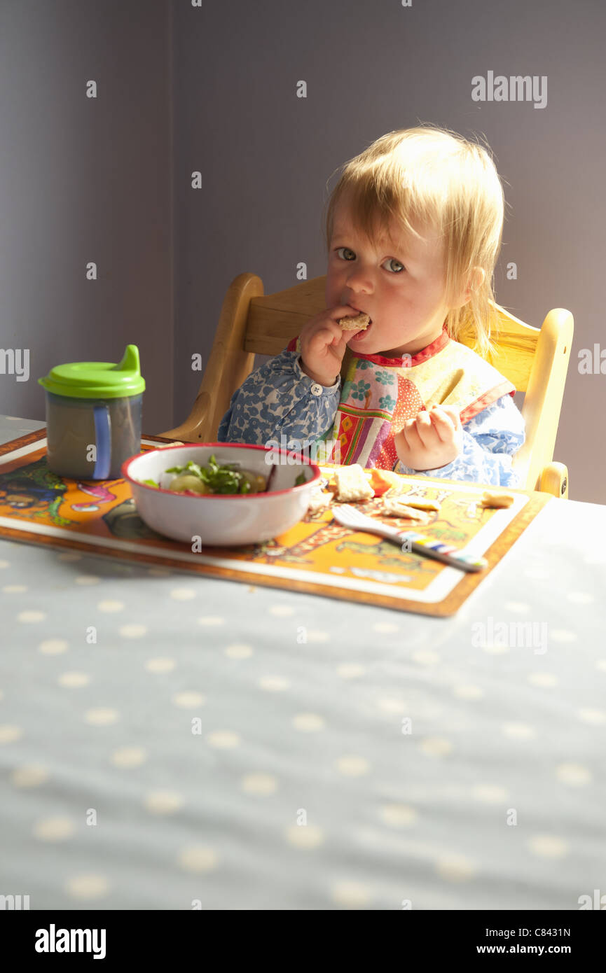 Kleinkind Mädchen am Tisch essen Stockfoto