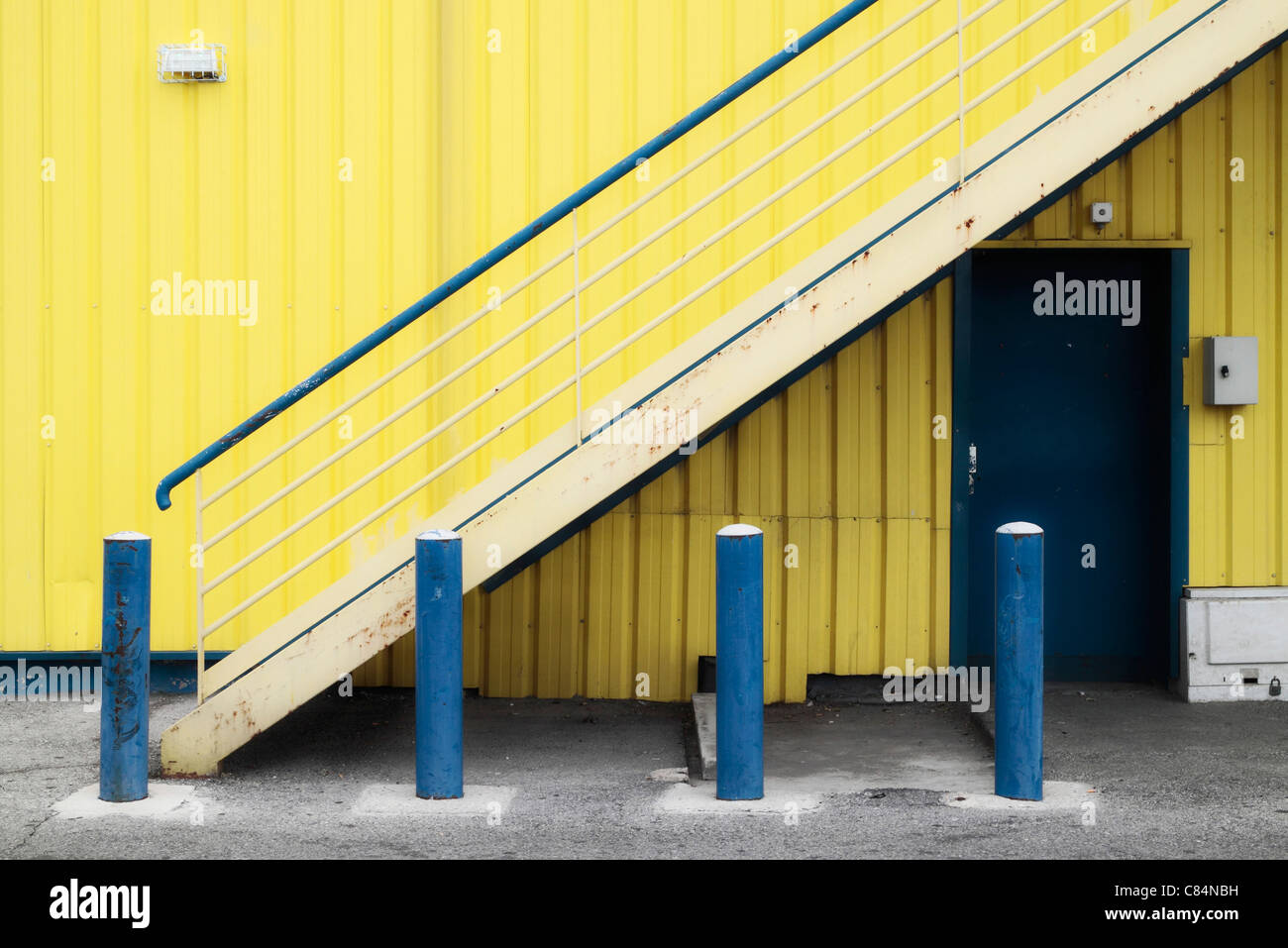 Gelbes Gebäude, blauen Poller Stockfoto