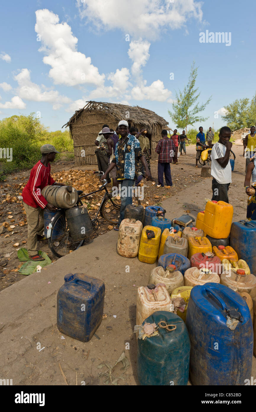 Menschen trinken Wasserholen in Behältern aus einem öffentlichen Hahn, Quelimane, Mosambik Stockfoto