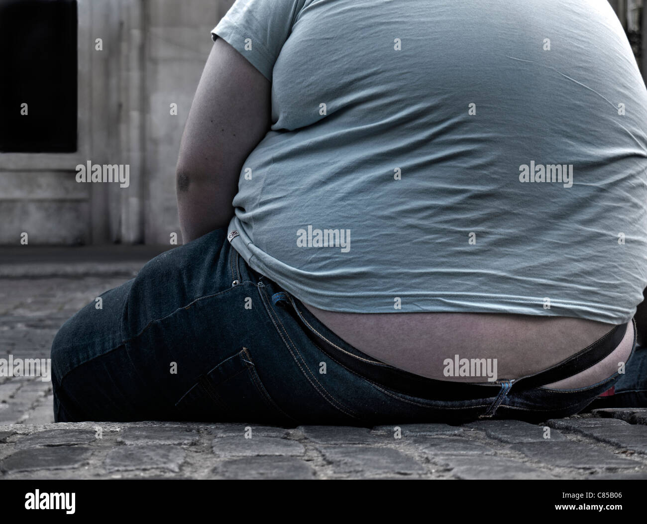 Krankhaft fettleibig Männer sitzen fangen den Atem an der Seite einer Straße Stockfoto