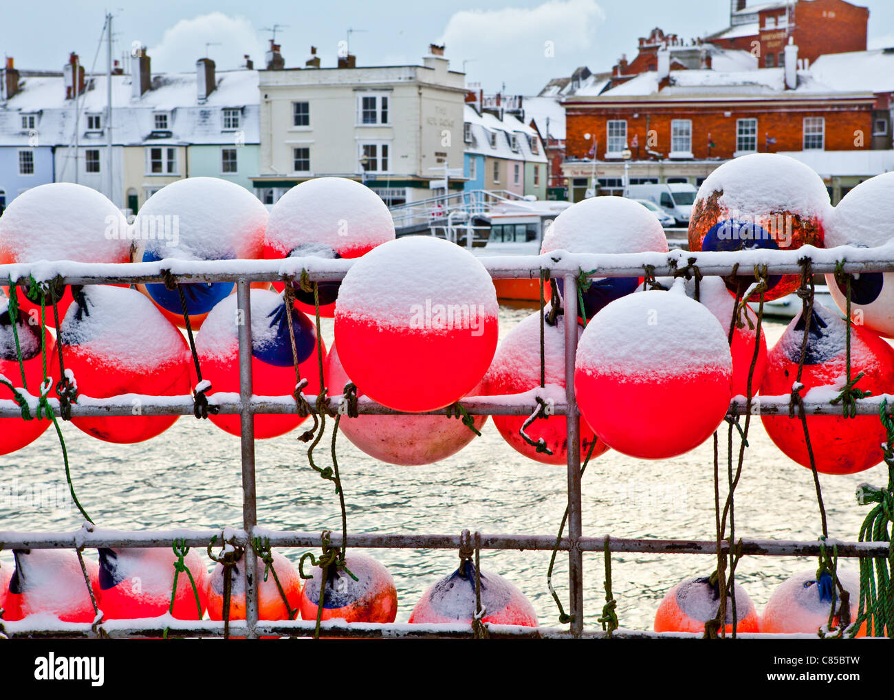 Schnee im Winter über die Schwimmer auf der Seite ein Fischerboot im Hafen von Weymouth Stockfoto