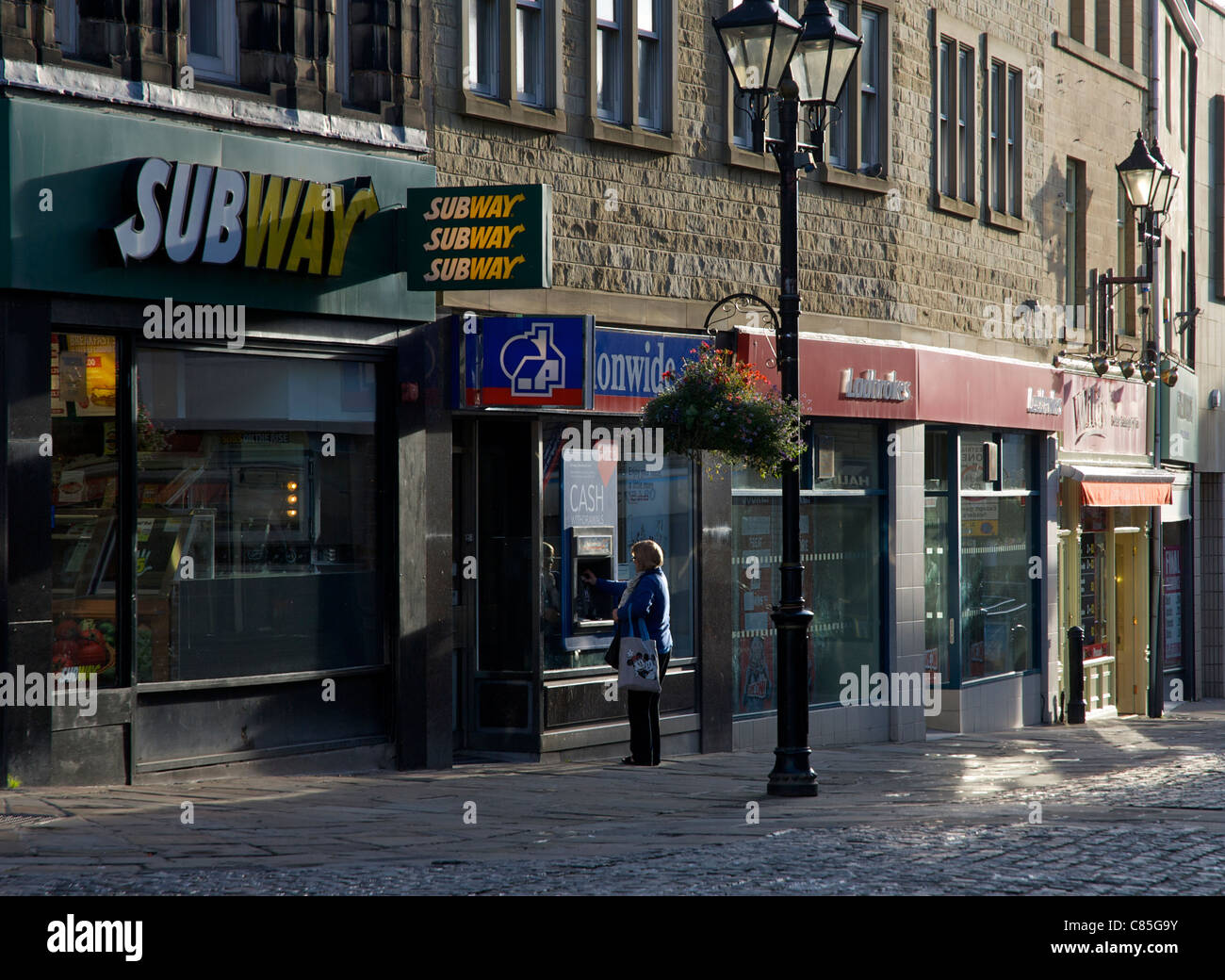Frau bekommen Geld von "Hole in the Wall", Keighley, West Yorkshire, England UK Stockfoto