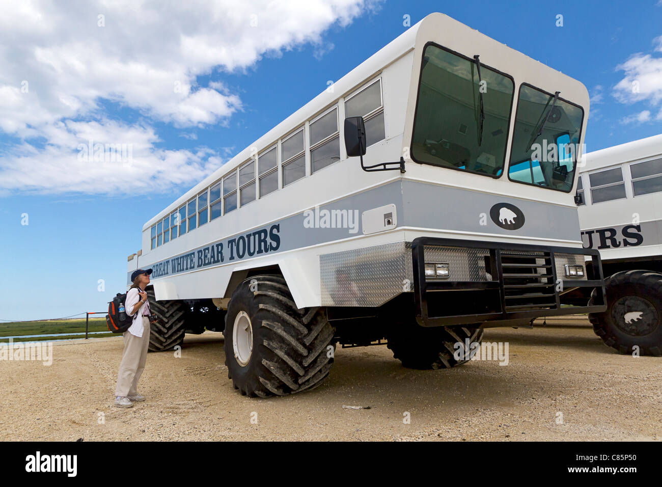 Frau untersucht "arktische Rover", ein Bus mit riesigen Reifen verwendet, um Tiere in der Tundra um Churchill, MB, Kanada zu sehen. Stockfoto